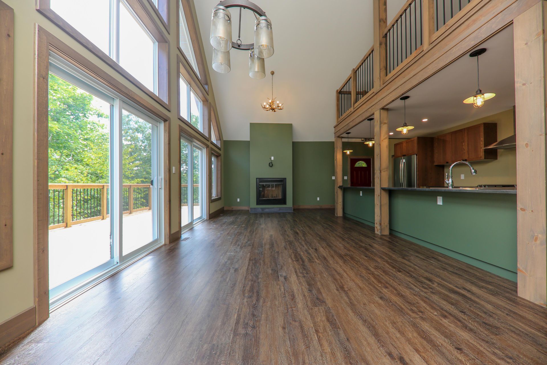 A large empty living room with hardwood floors and a fireplace.