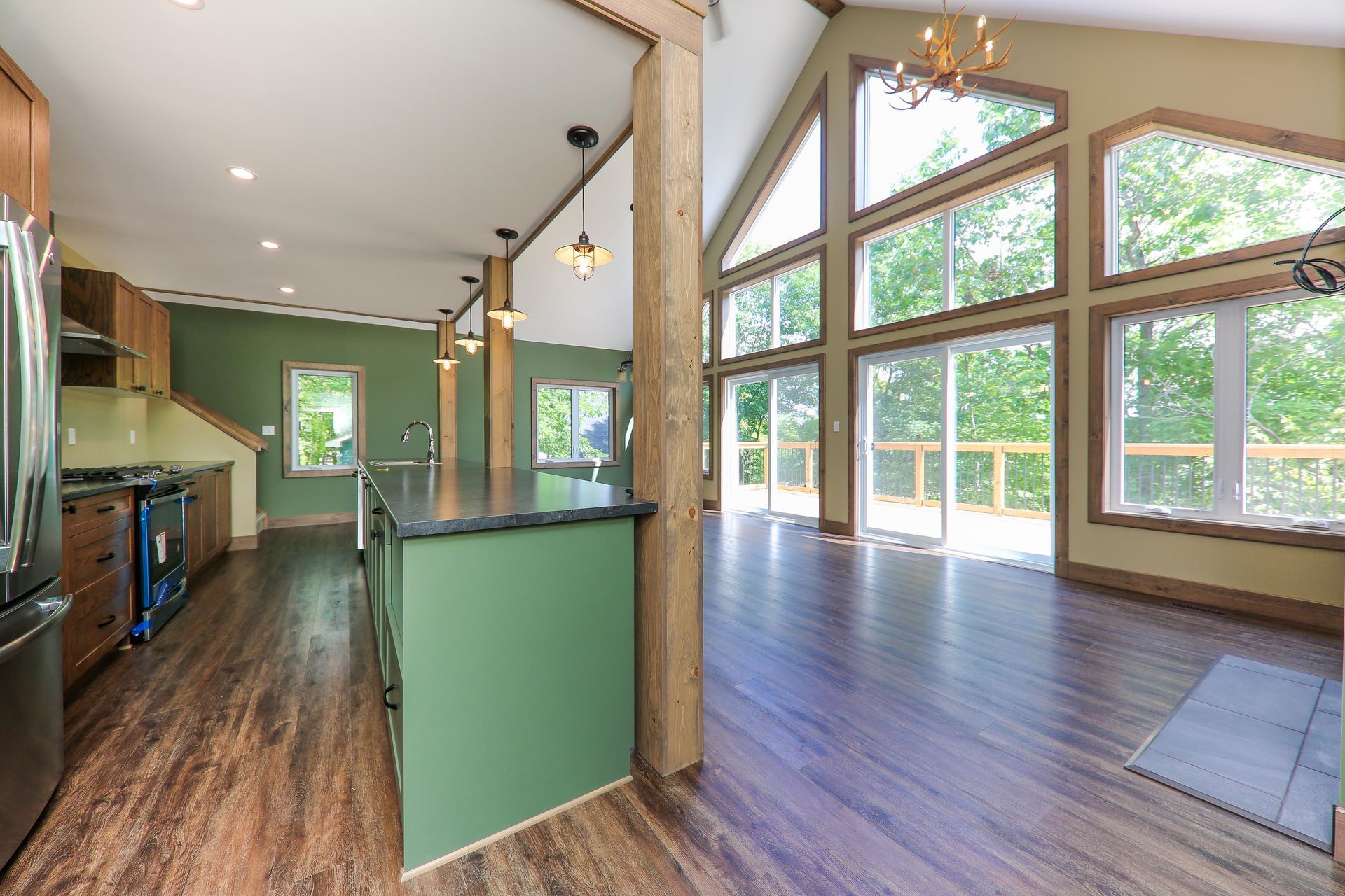 A kitchen with a green island and a lot of windows