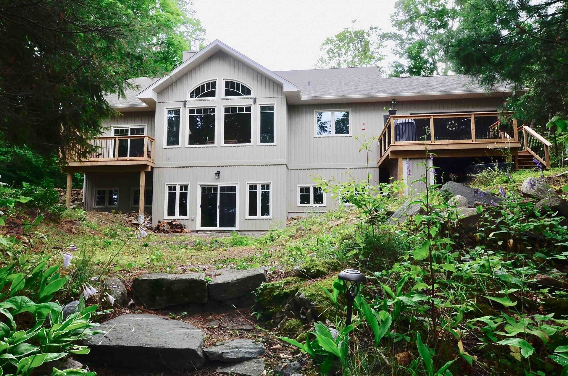 A large house with a lot of windows is surrounded by trees