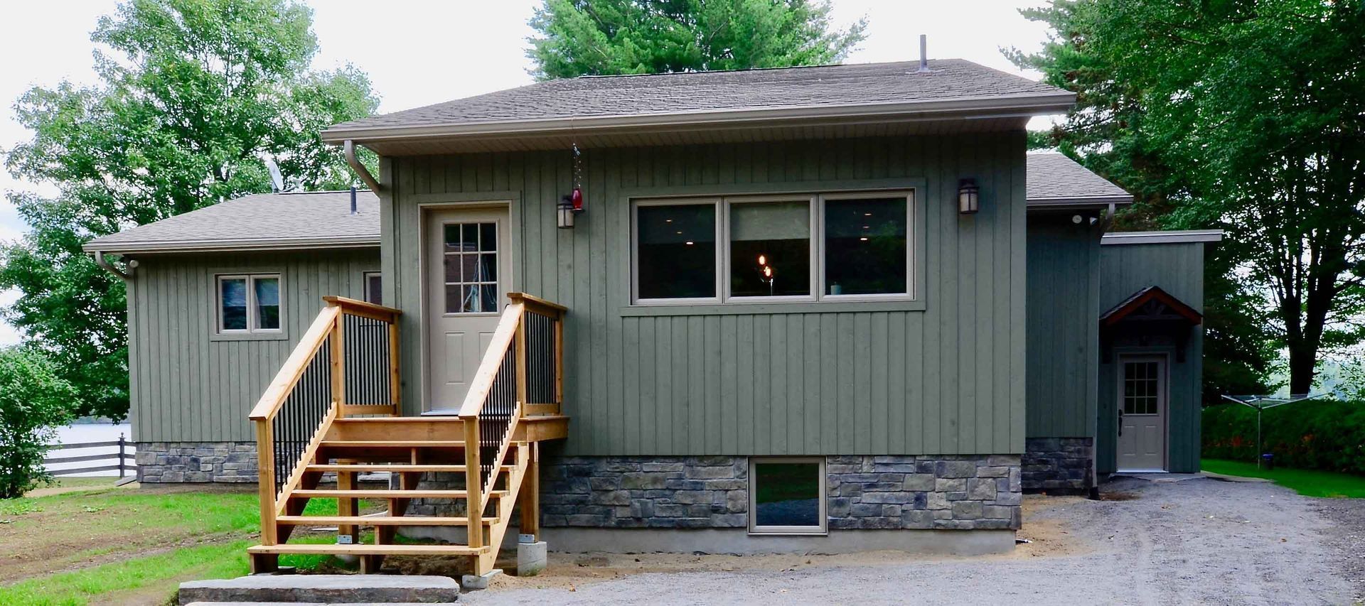A small house with stairs leading up to the front door.