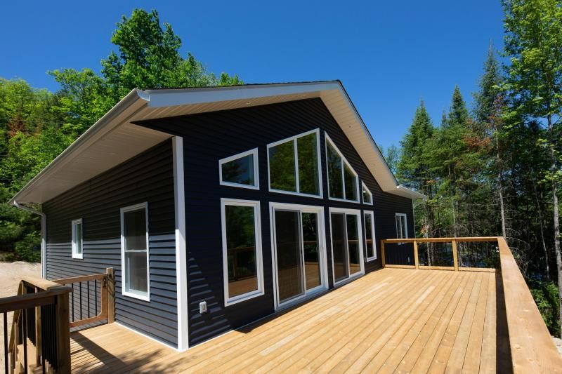 A black house with a large deck in front of it