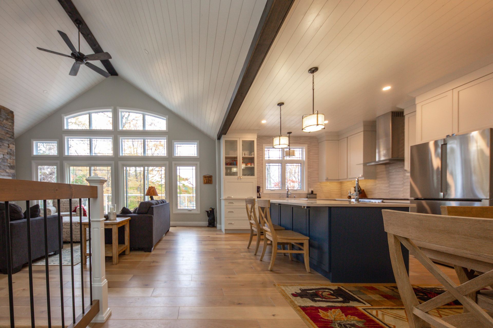 A kitchen and living room in a house with a vaulted ceiling.