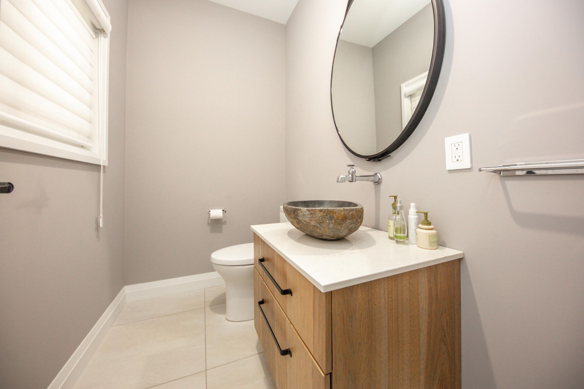 A bathroom with a sink , toilet and mirror.