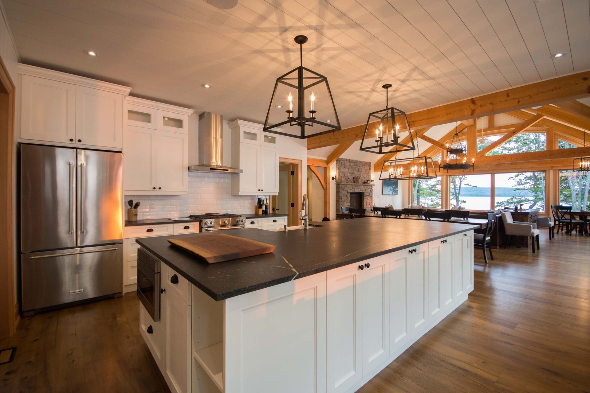 A kitchen with white cabinets , stainless steel appliances , and a large island.