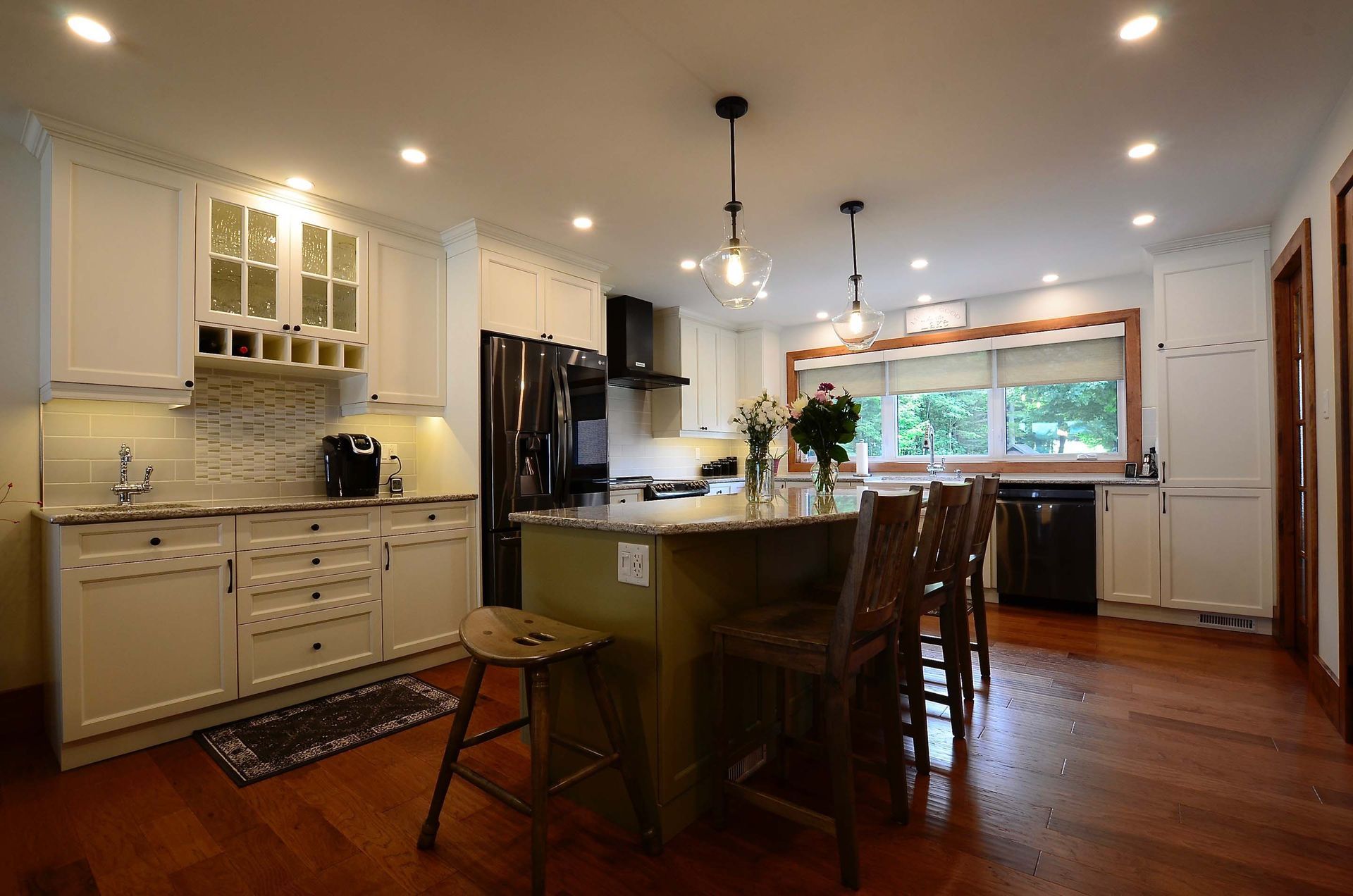 A kitchen with white cabinets and a large island in the middle.