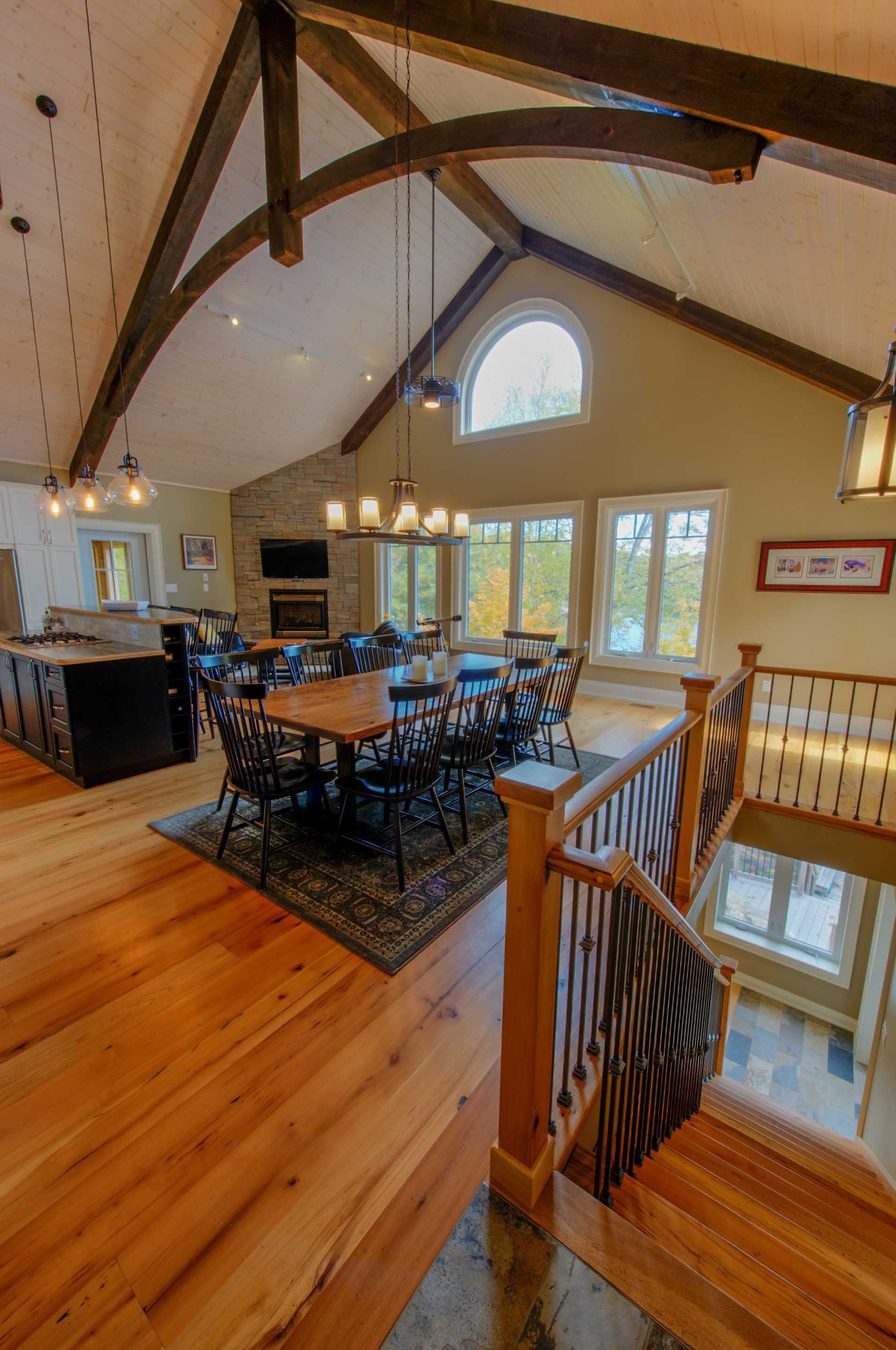 A large room with tables and chairs and stairs leading up to it.