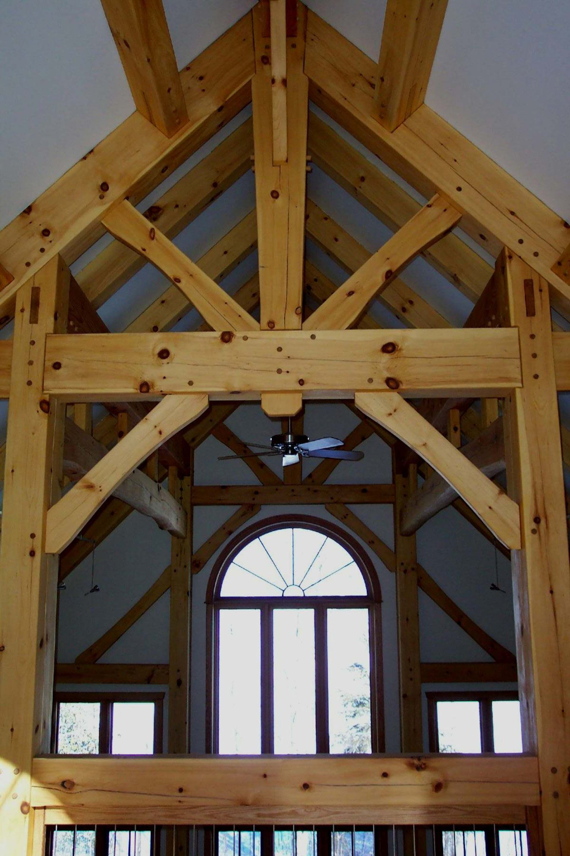 A wooden structure with arched windows and a ceiling fan