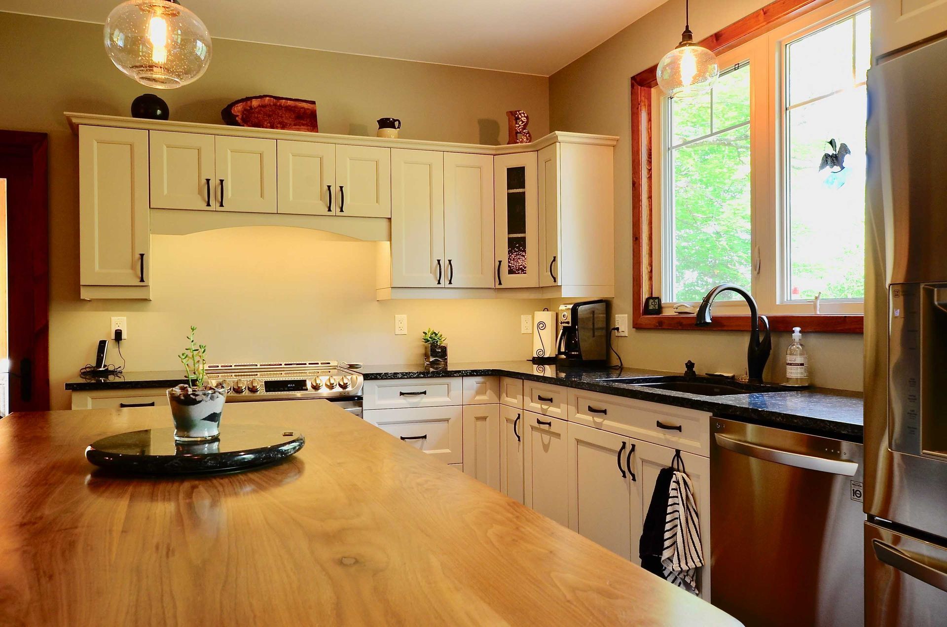 A kitchen with white cabinets and black counter tops