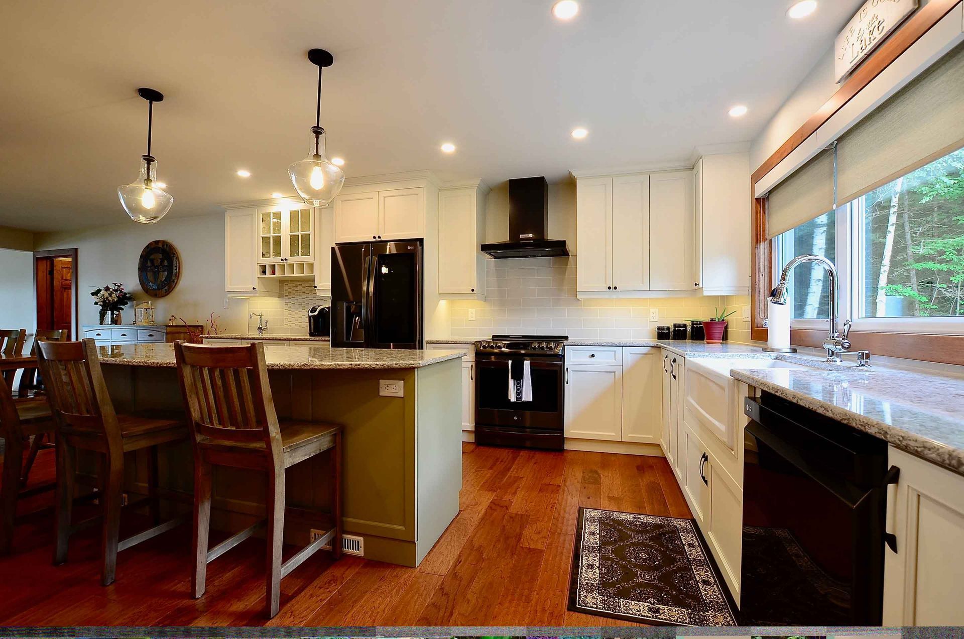 A kitchen with white cabinets and a black refrigerator