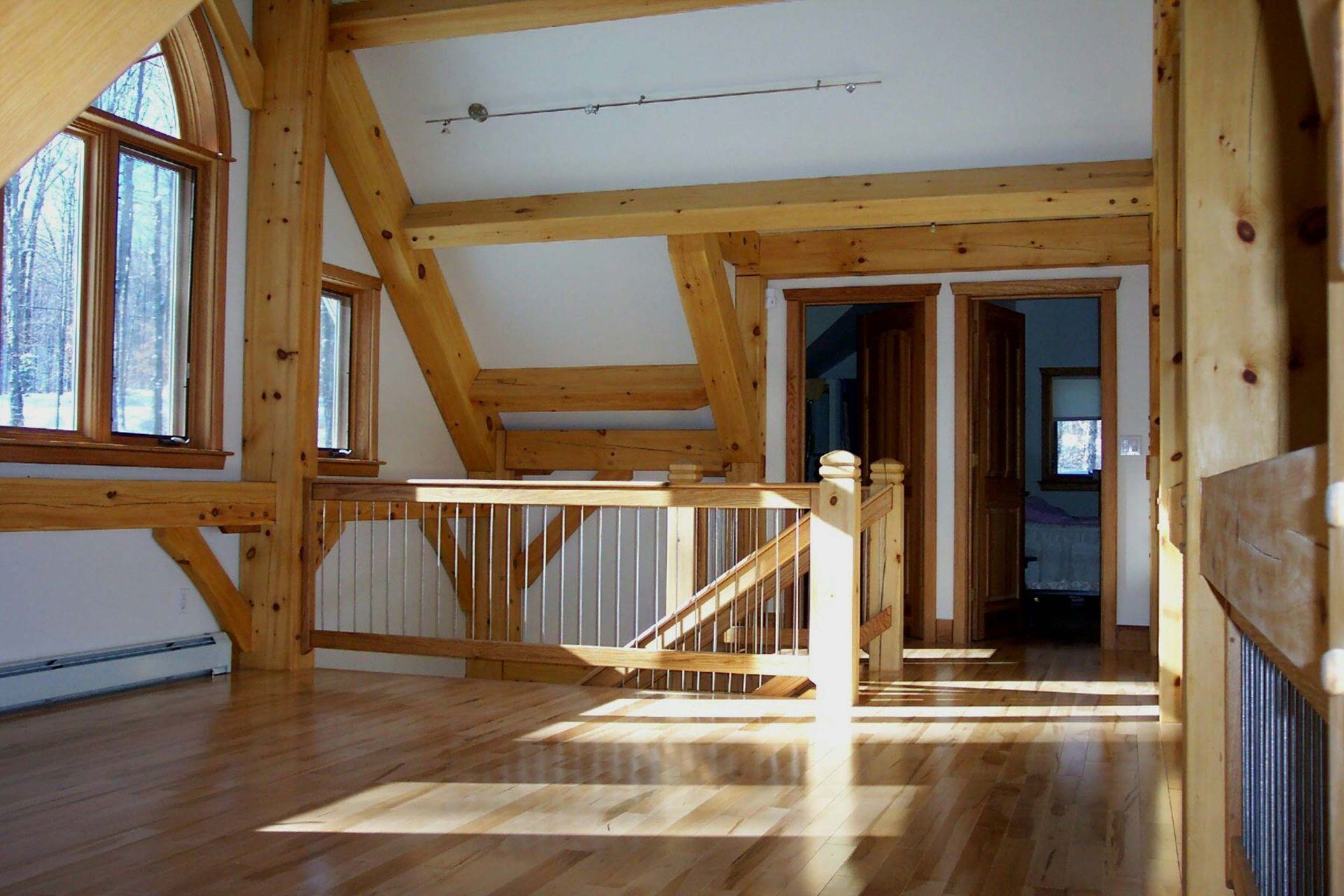 An empty room with wooden beams and a staircase