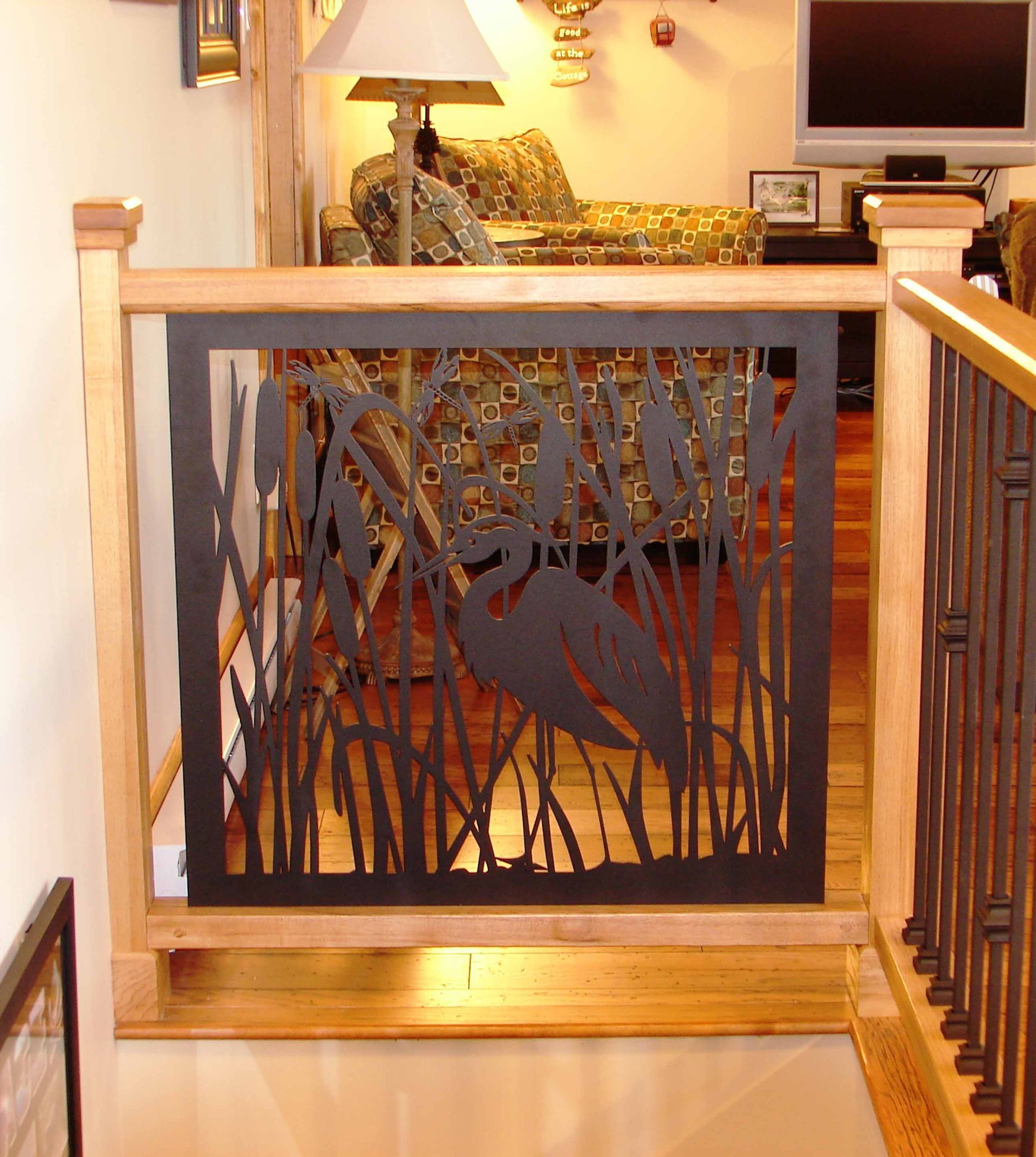 A wooden staircase with a black railing and a couch in the background