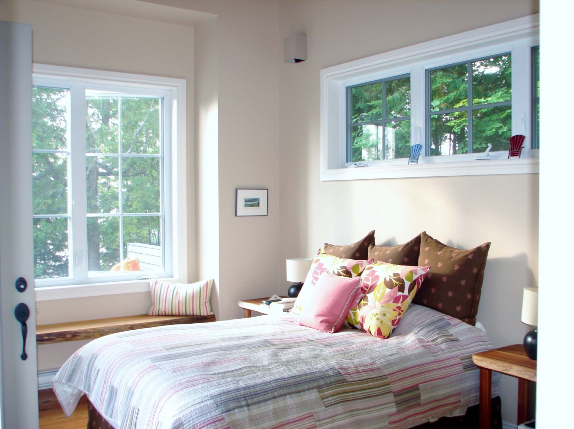 A bedroom with a large bed and lots of windows