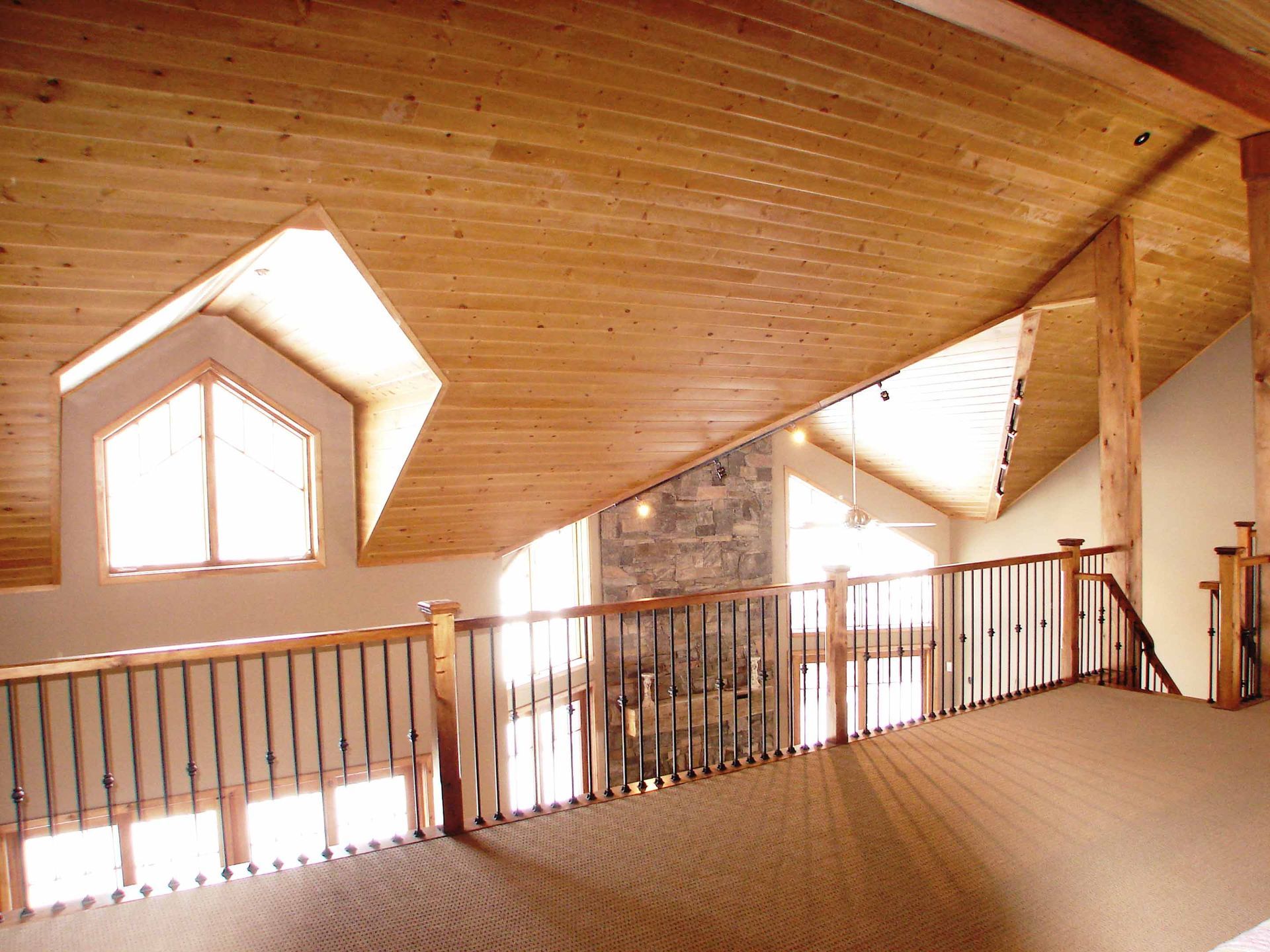 An empty room with a wooden ceiling and stairs