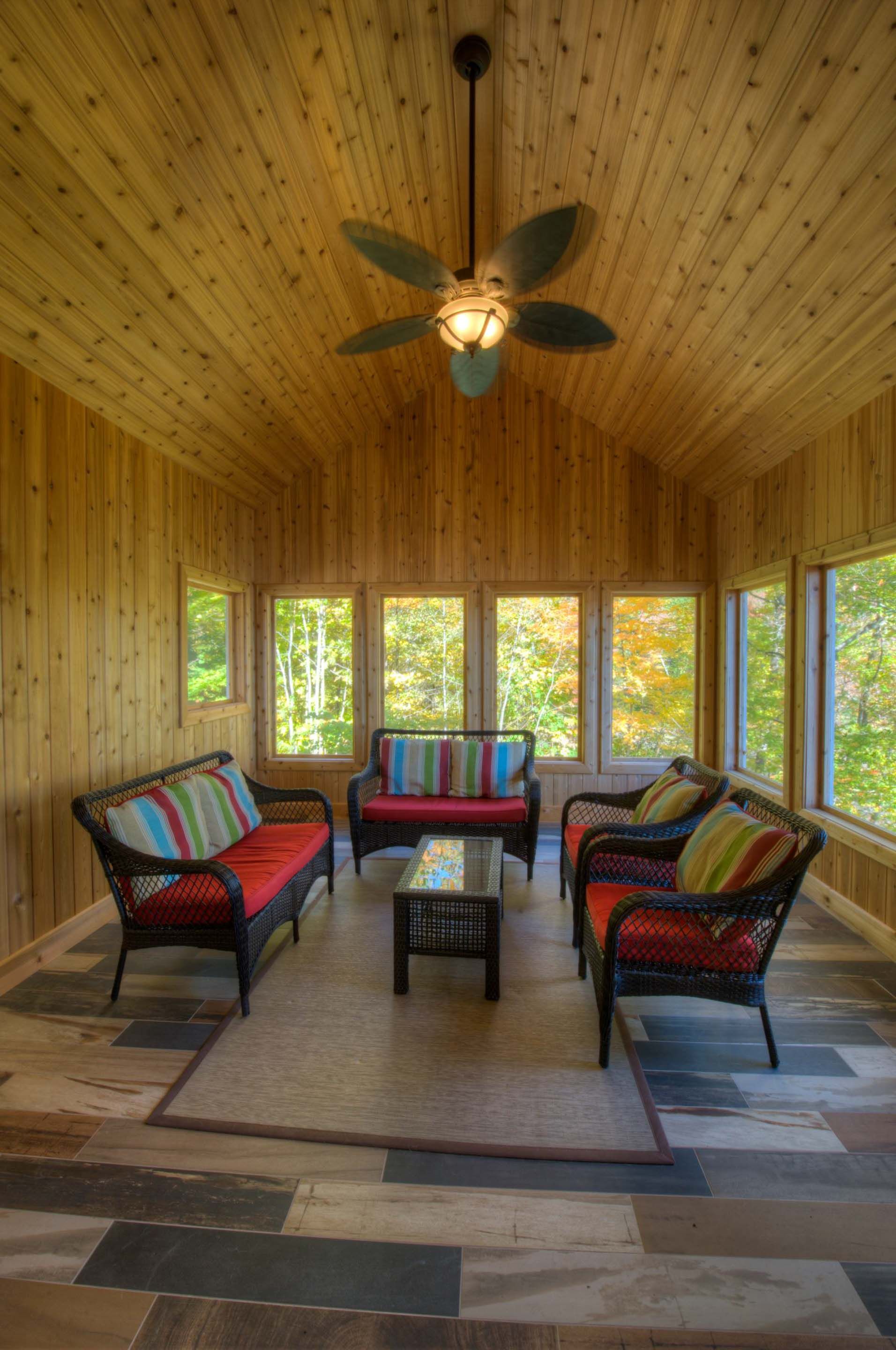 A living room with a lot of furniture and a ceiling fan.