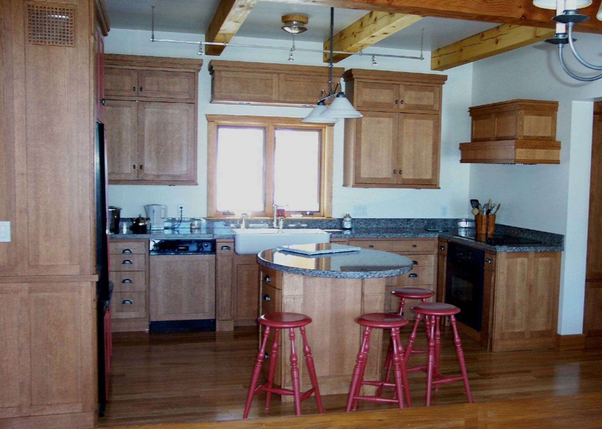 A kitchen with wooden cabinets and red stools