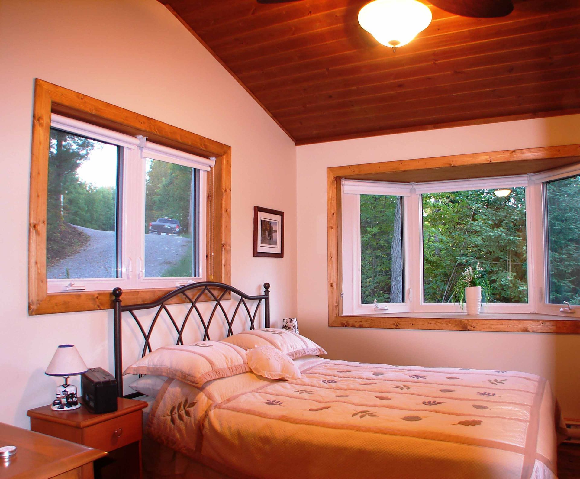 A bedroom with a large bed and lots of windows