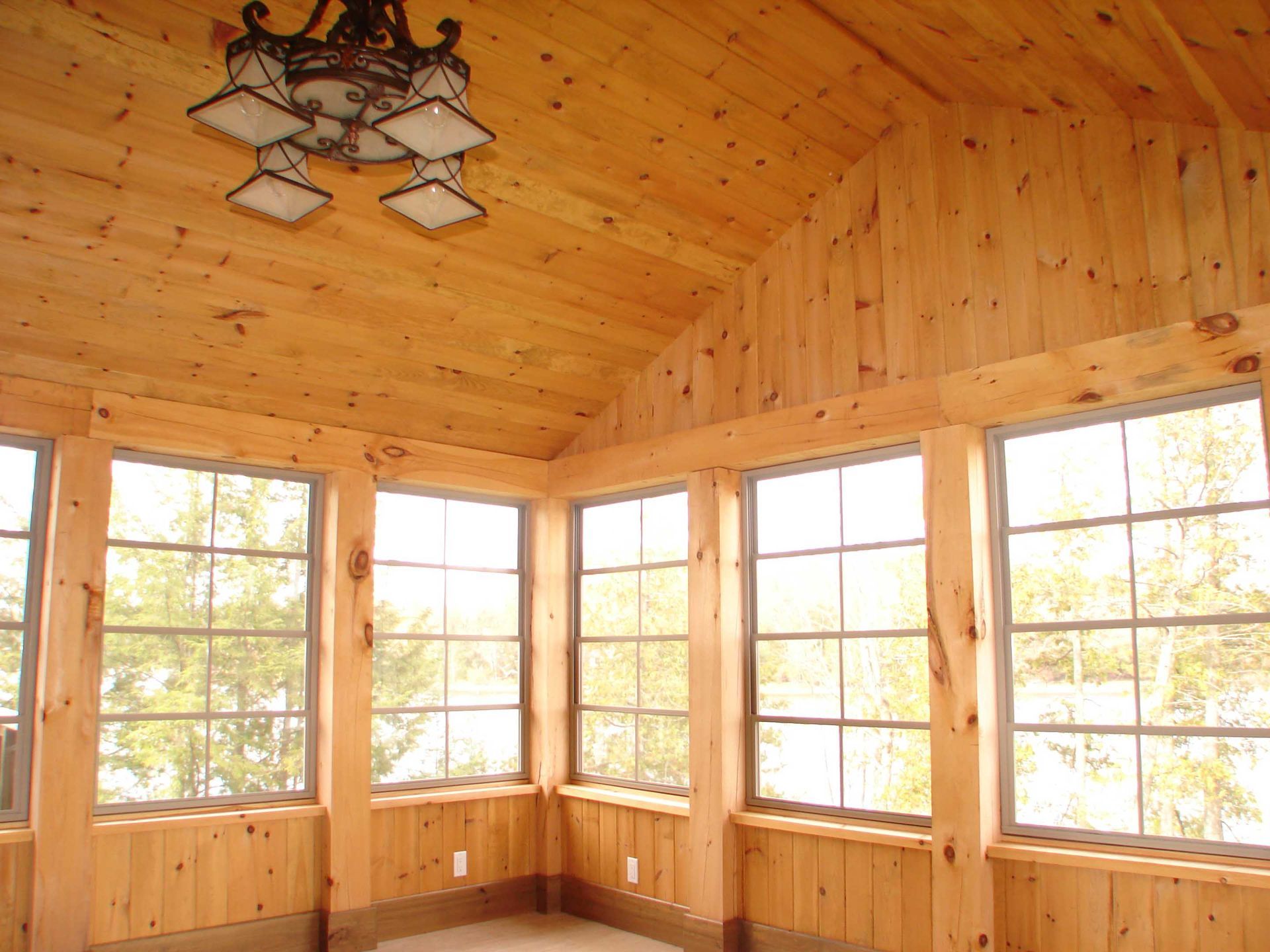 A room with lots of windows and a chandelier hanging from the ceiling