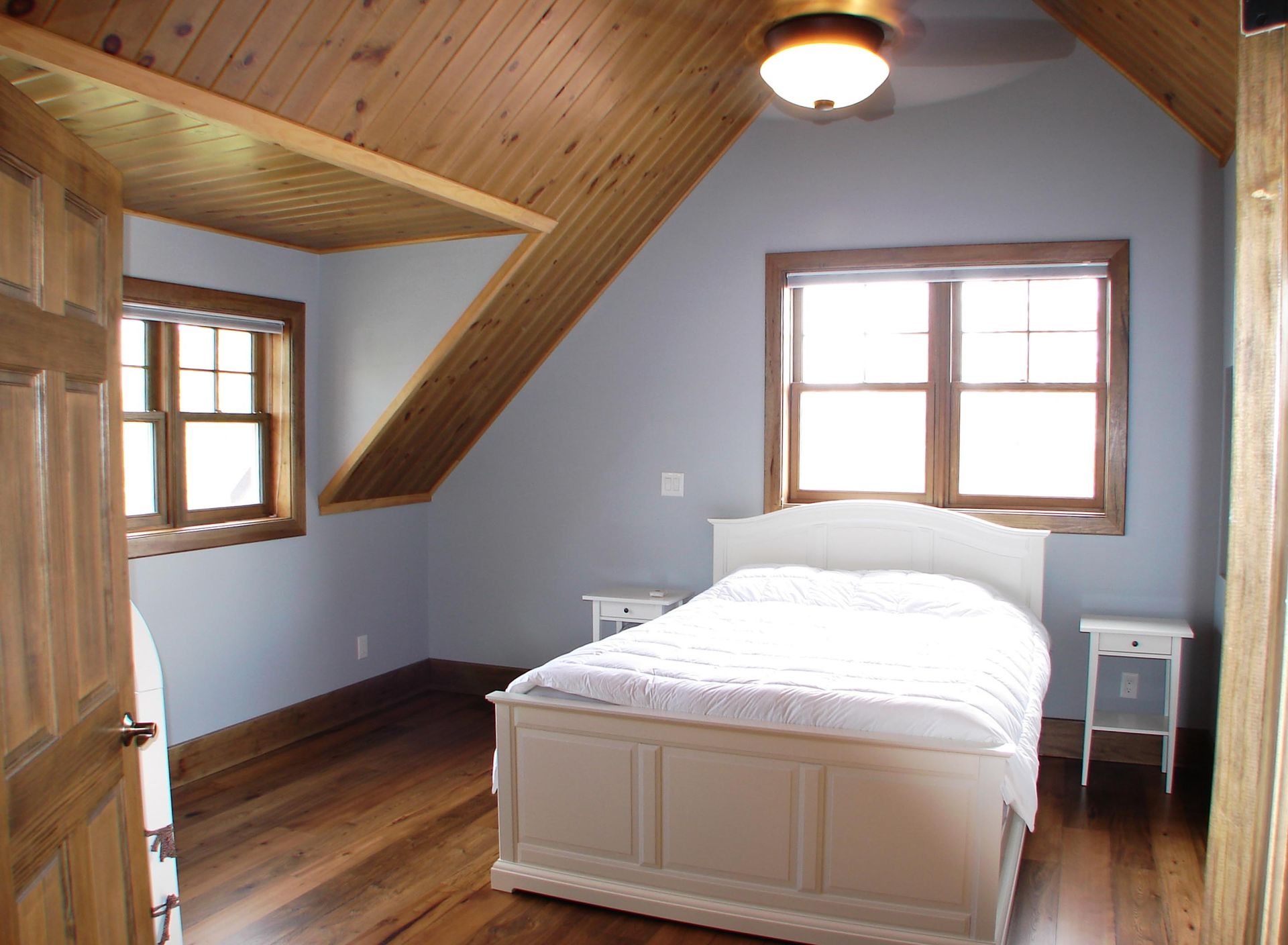 A bedroom with a ceiling fan and a bed