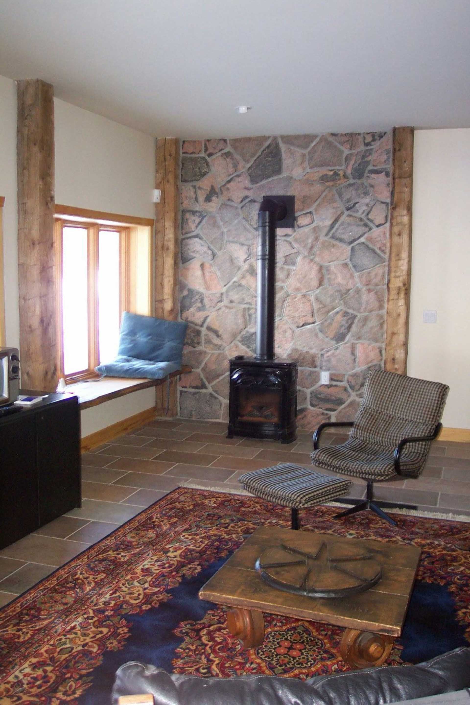 A living room with a fireplace , chairs , and a rug.