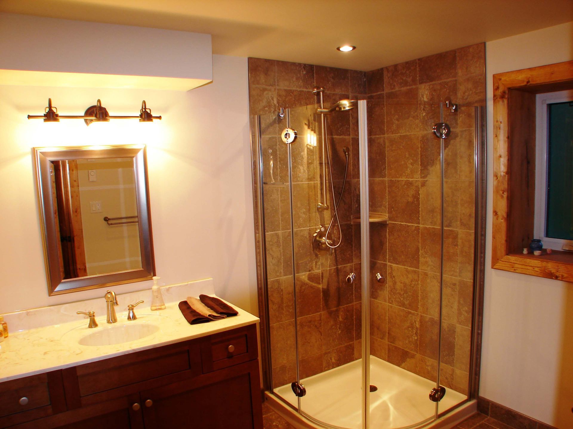 A bathroom with a walk in shower and a sink