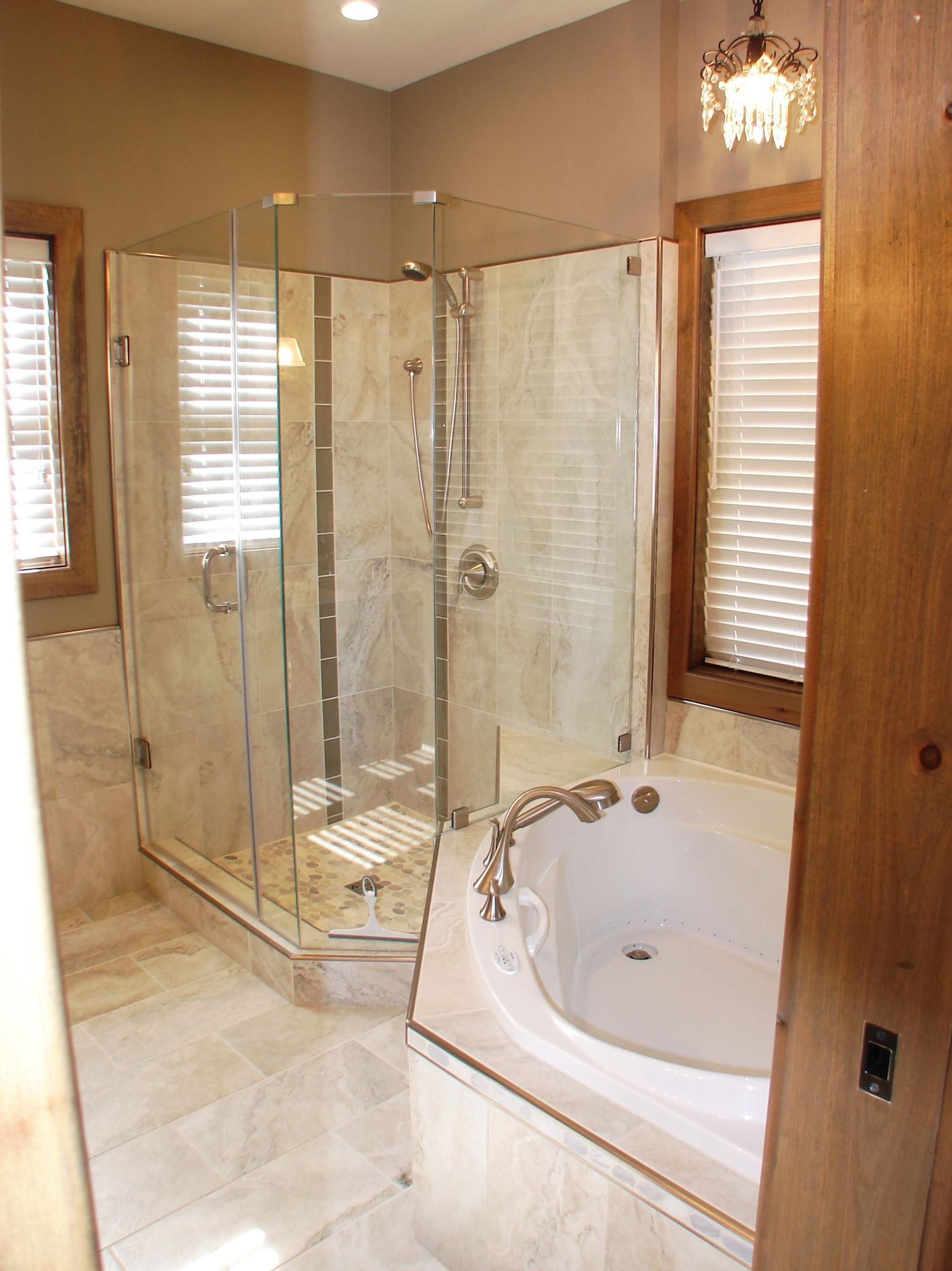 A bathroom with a tub , shower , and window.