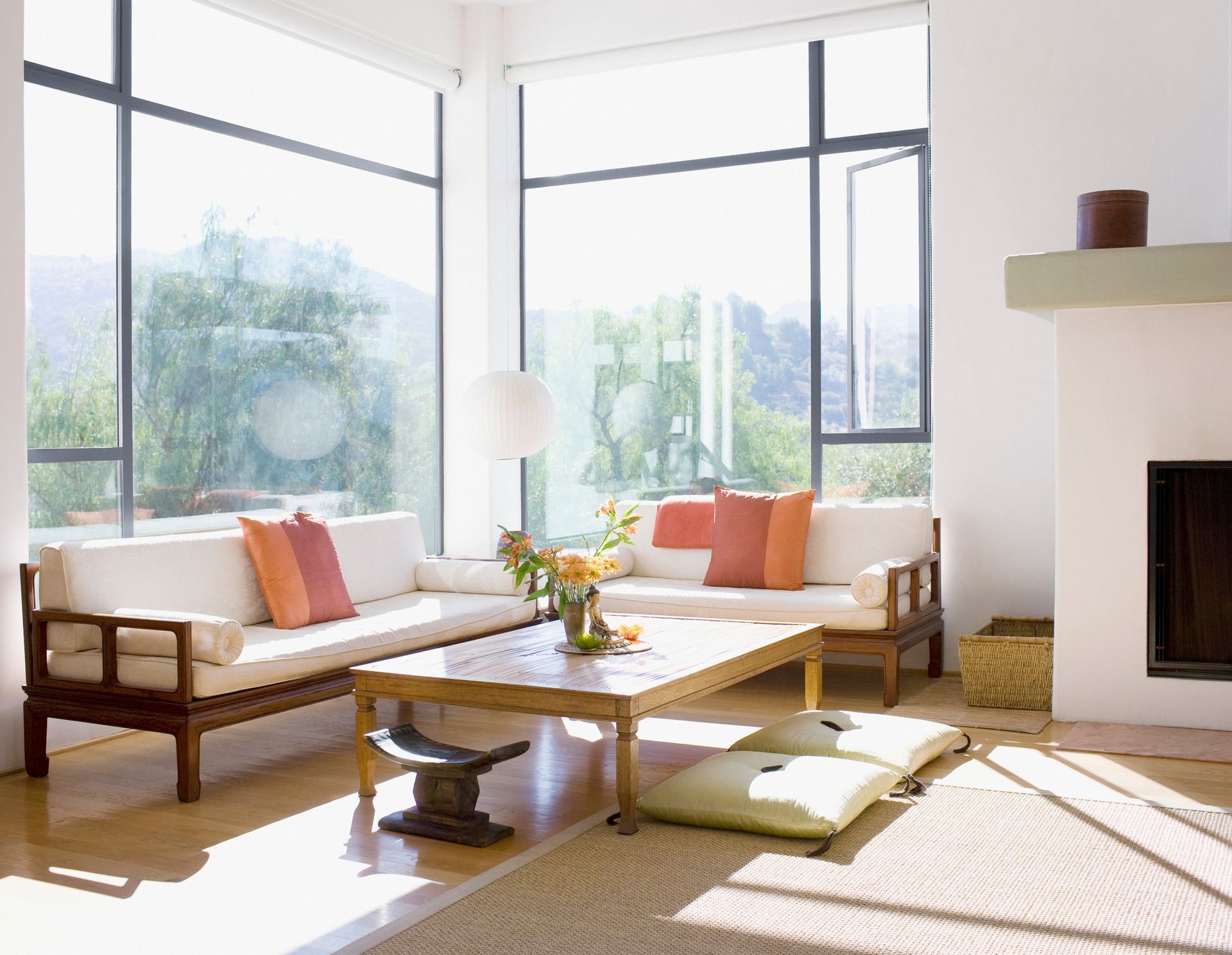 Spacious living room in a custom home with white furniture and large windows full of natural light.