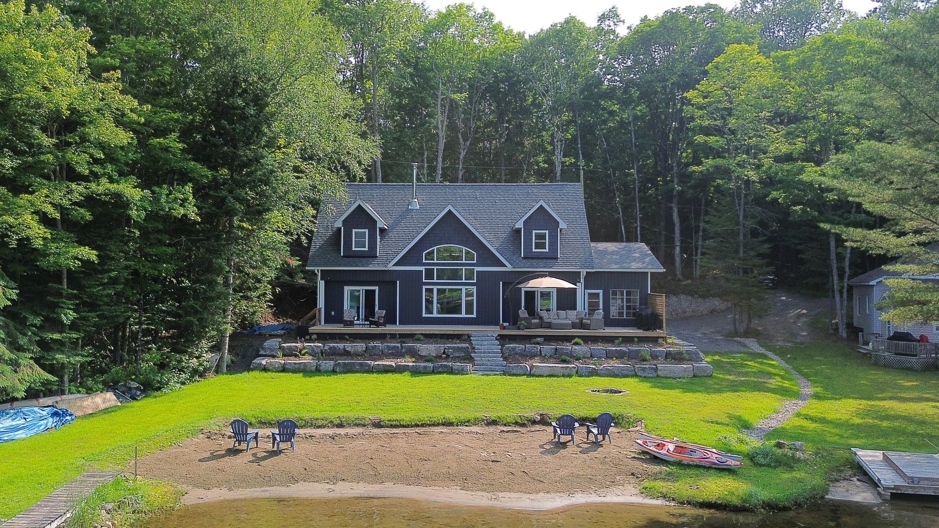 An aerial view of a house with a lake in front of it