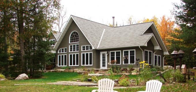A large house with a lot of windows is surrounded by trees.