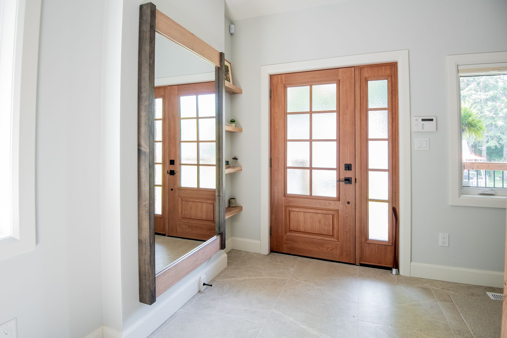 A hallway with a large mirror and a wooden door.