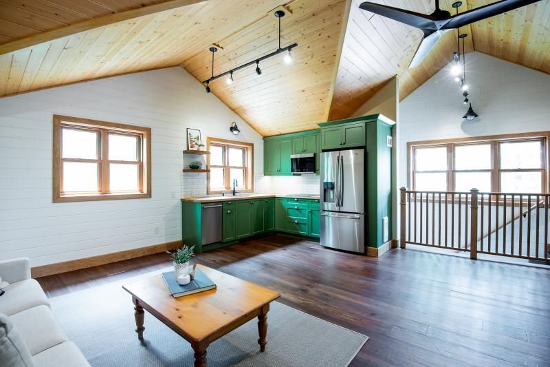 A living room with green cabinets and a ceiling fan