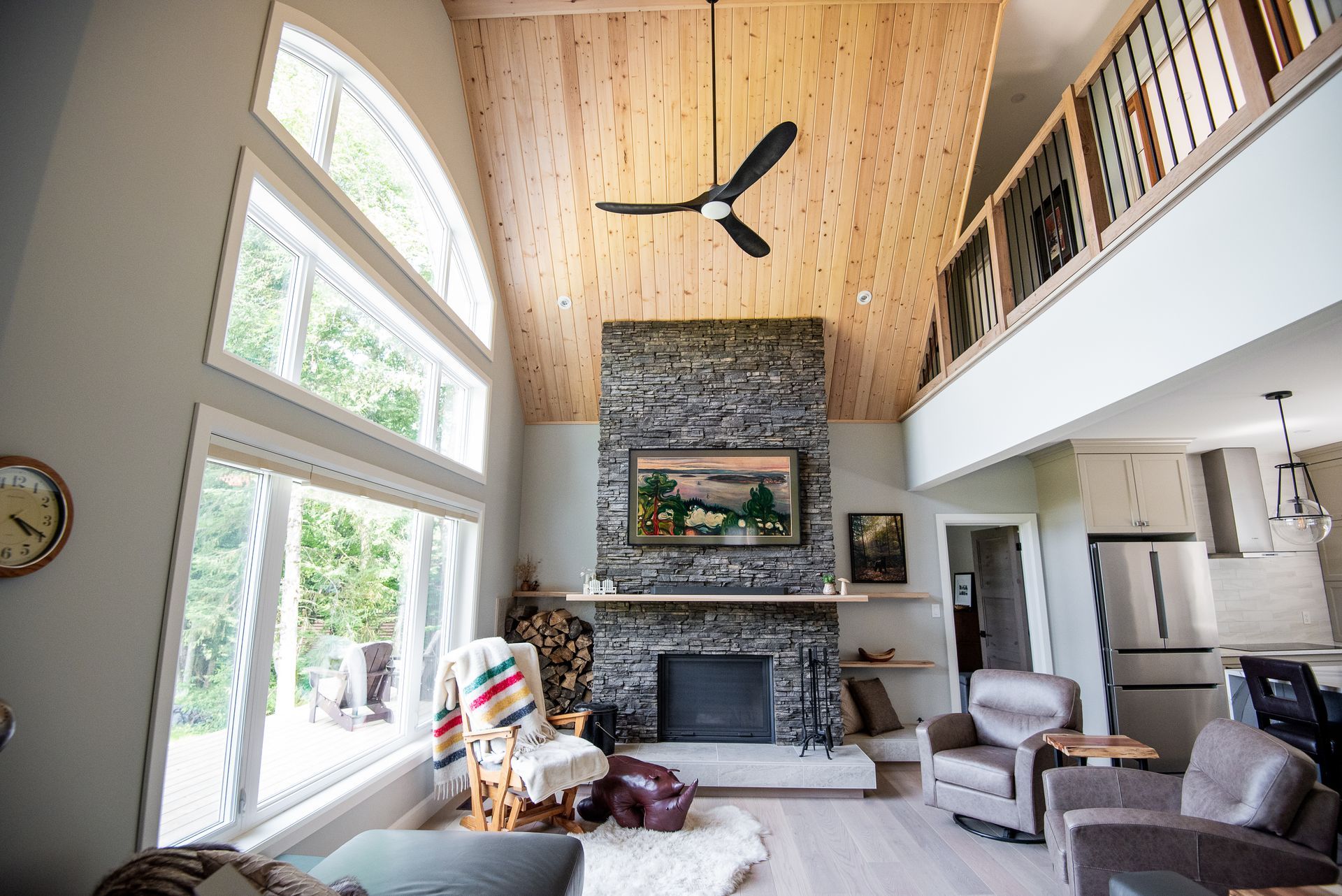A living room with a fireplace and a ceiling fan.