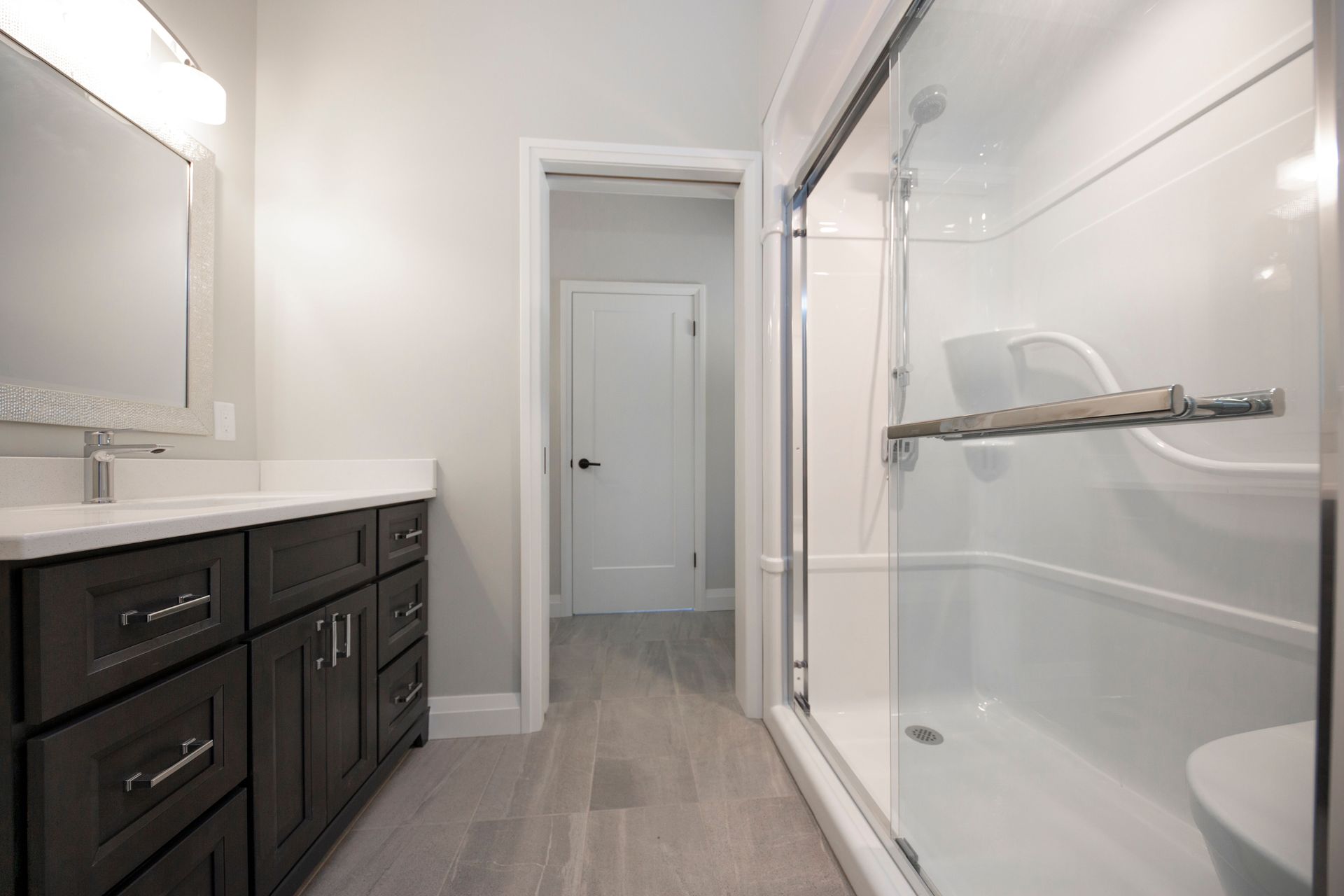 A bathroom with two sinks , a toilet , and a walk in shower.