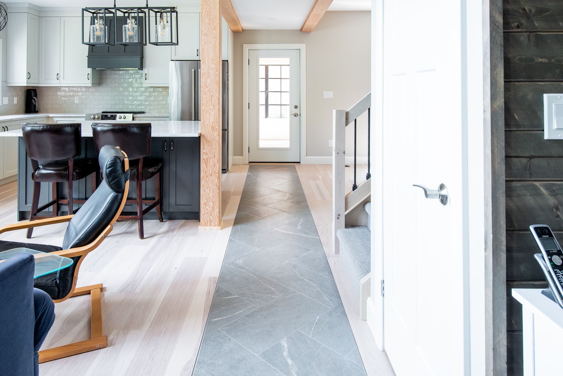 A hallway leading to a kitchen and stairs in a house.