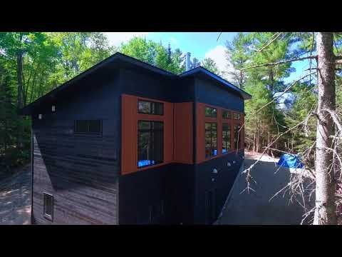 An aerial view of a house in the middle of a forest.