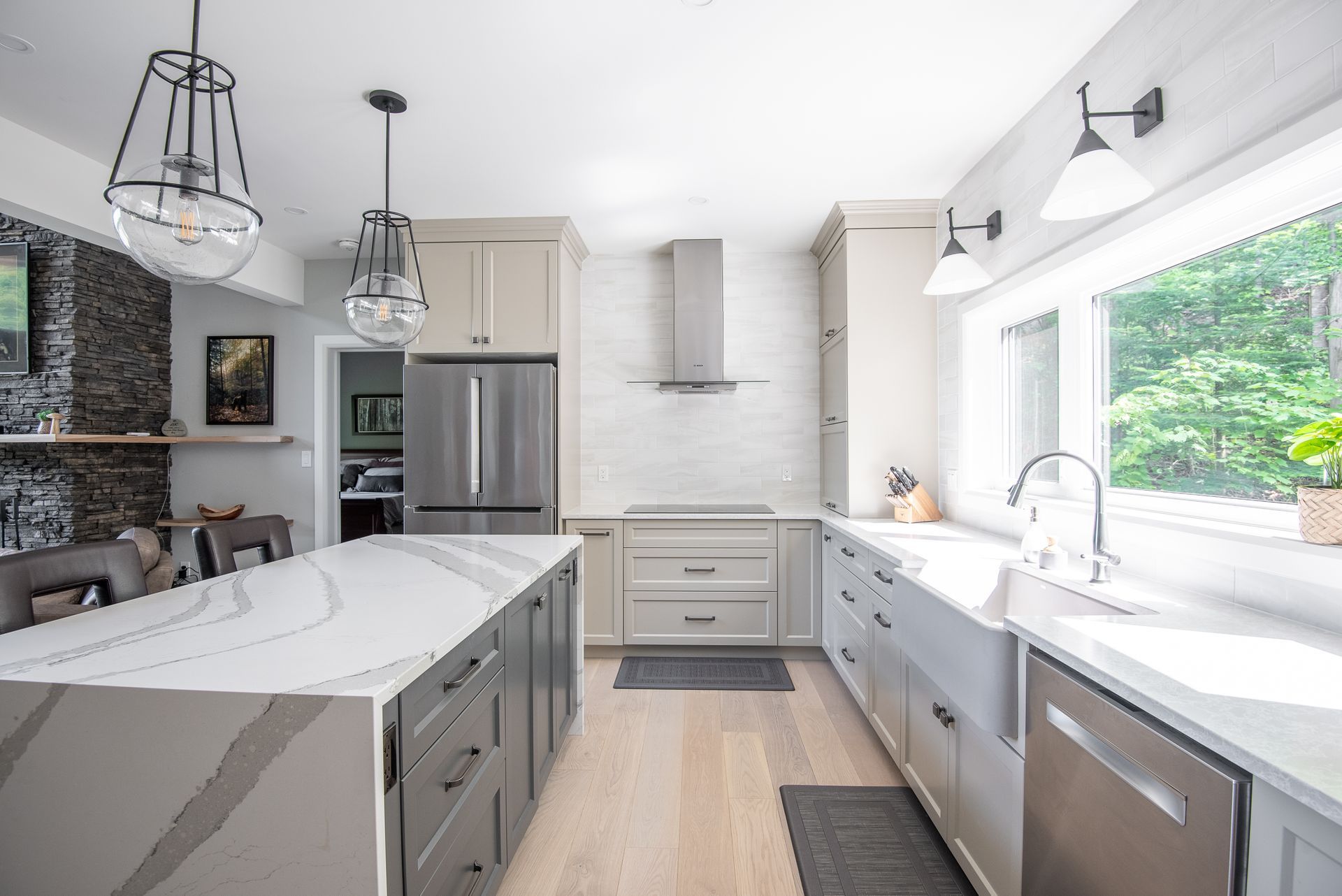 A kitchen with stainless steel appliances and a large island in the middle.