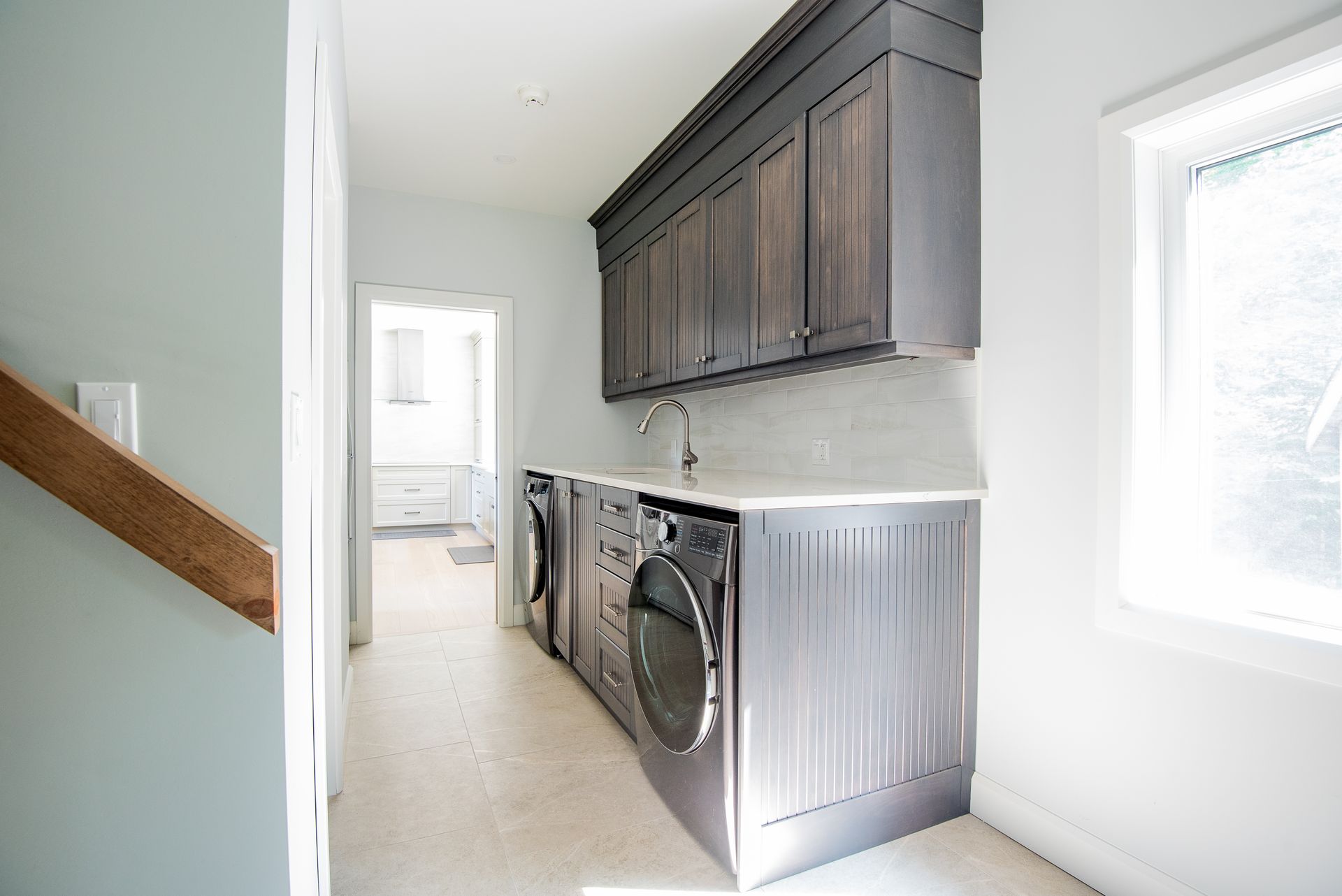 A laundry room with a washer and dryer and a sink.