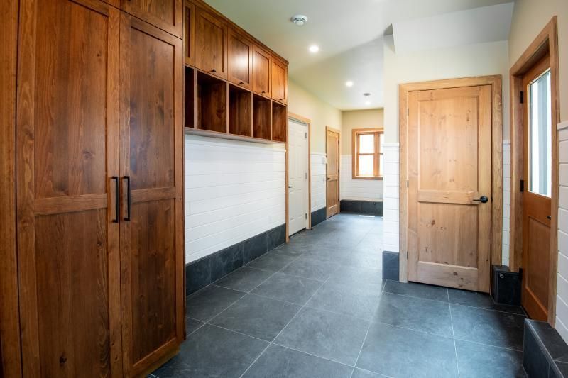 A hallway with wooden cabinets and tile floors in a house.