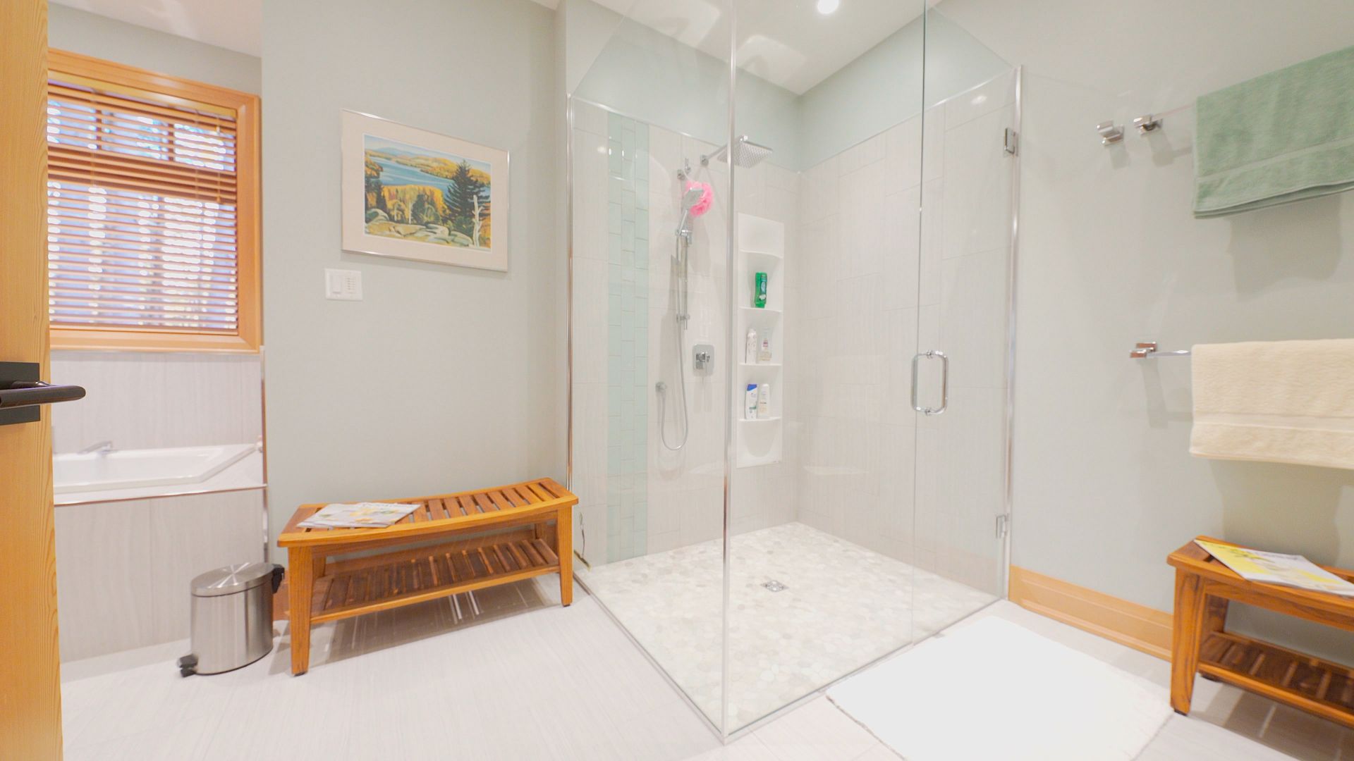A bathroom with a walk in shower and a bench.