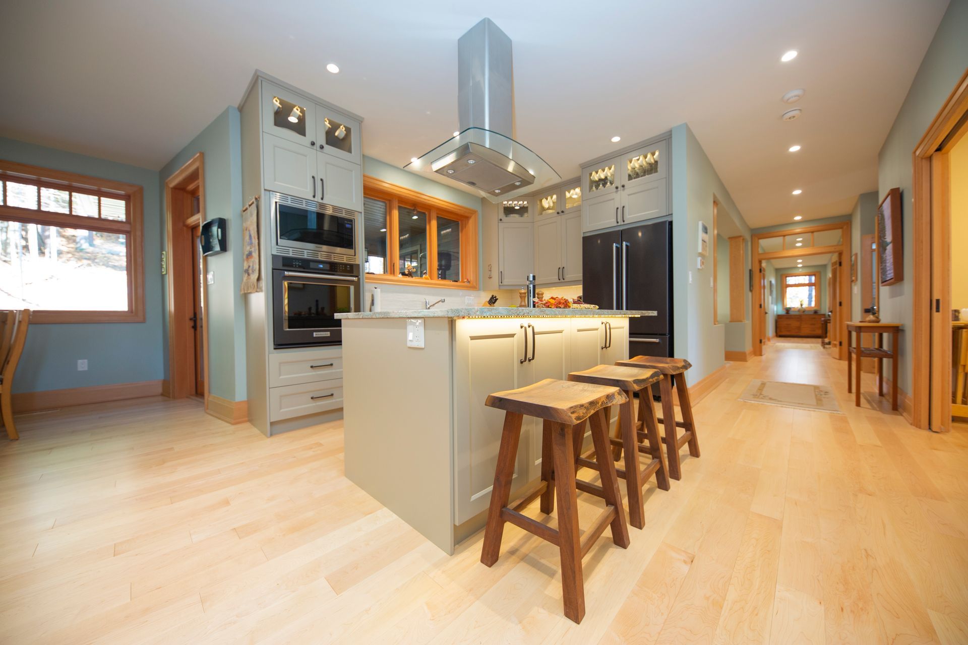 A kitchen with a large island and stools in it.