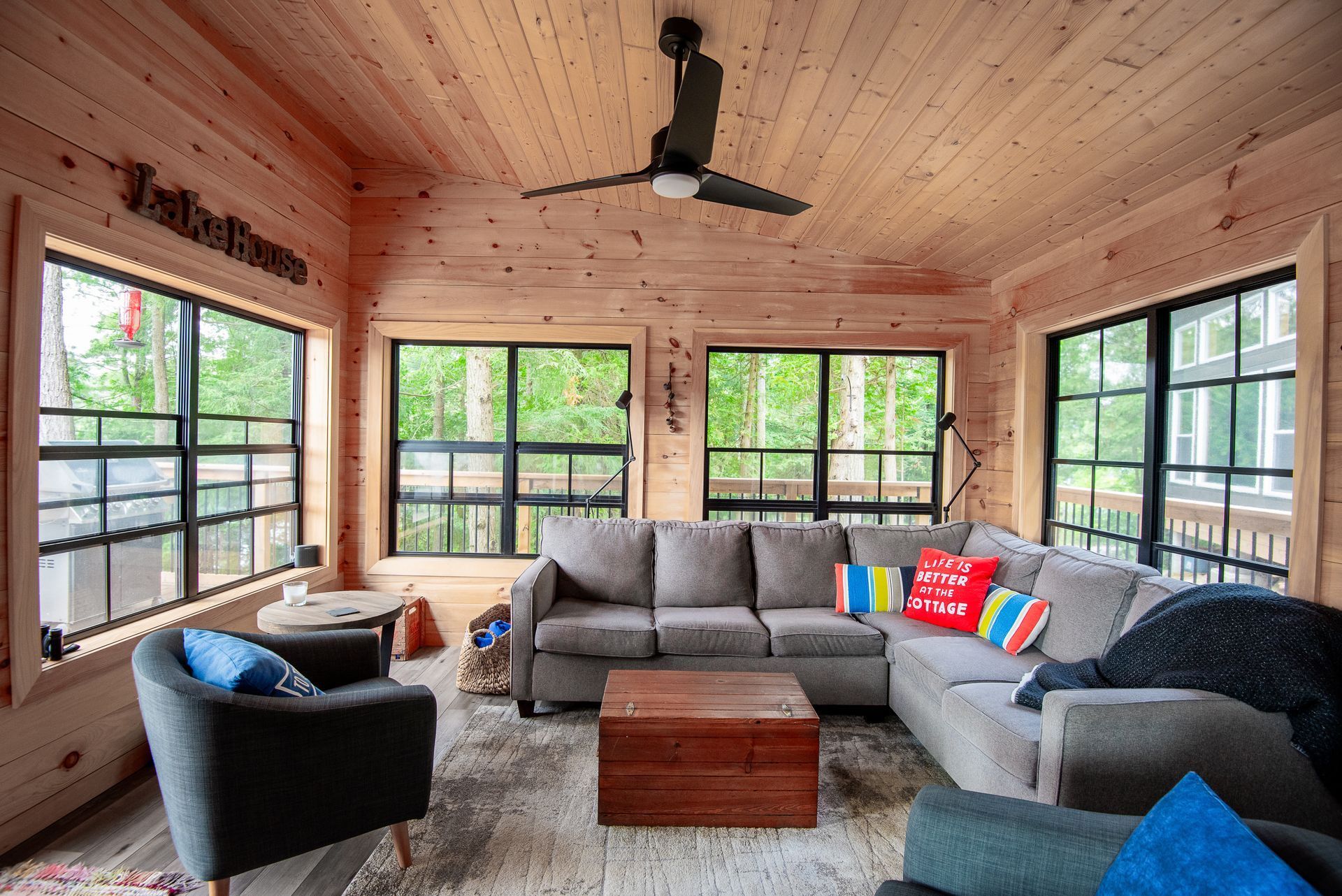 A living room with a couch , chairs , and a ceiling fan.