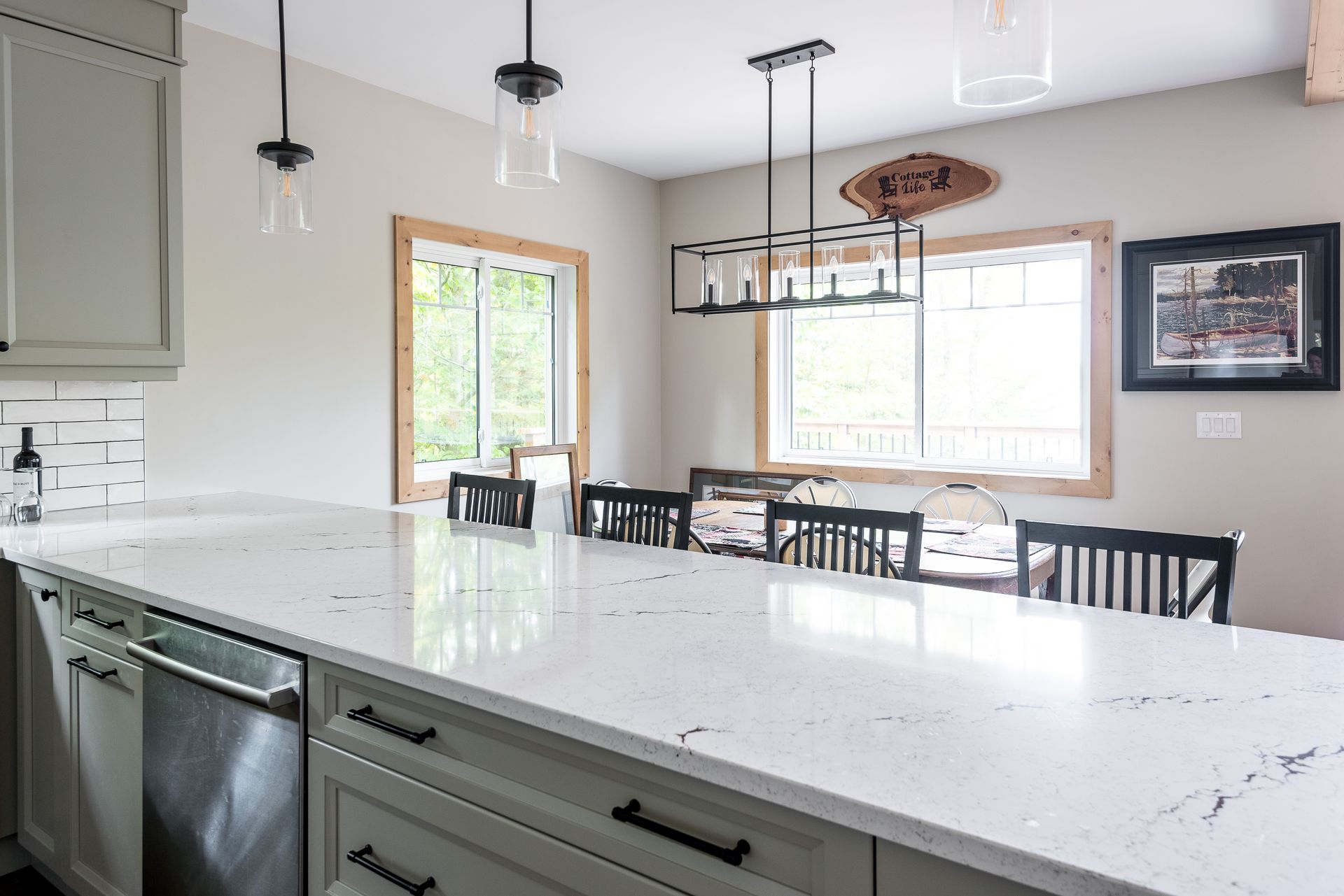 A kitchen with a large white counter top and stainless steel appliances.