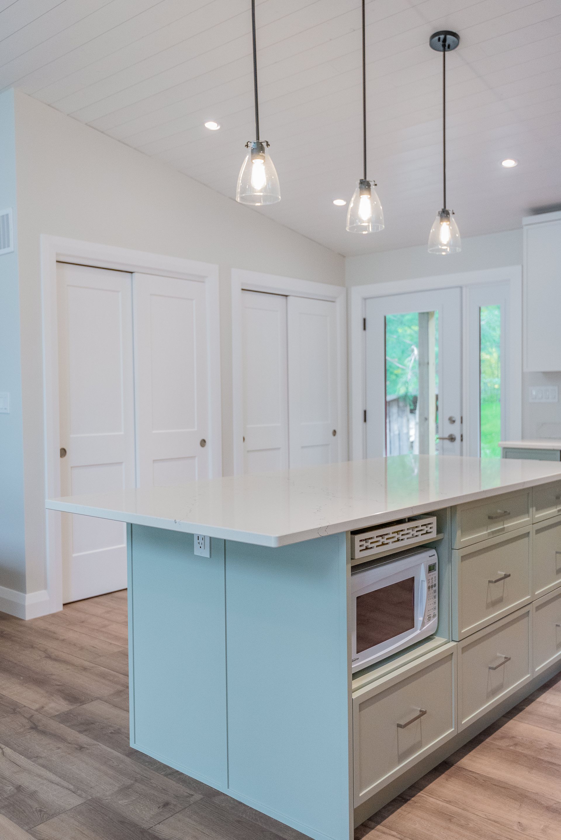 A kitchen with a large island and a microwave oven.