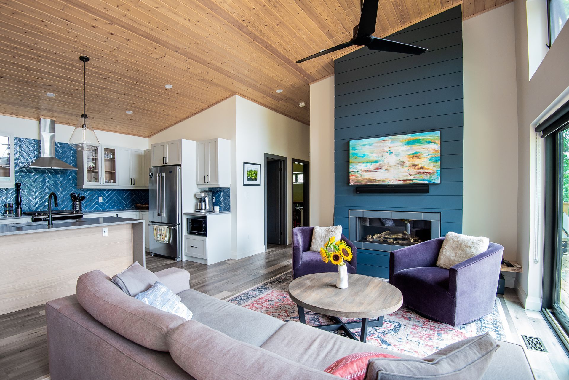 A living room with a couch , chairs , table and television.