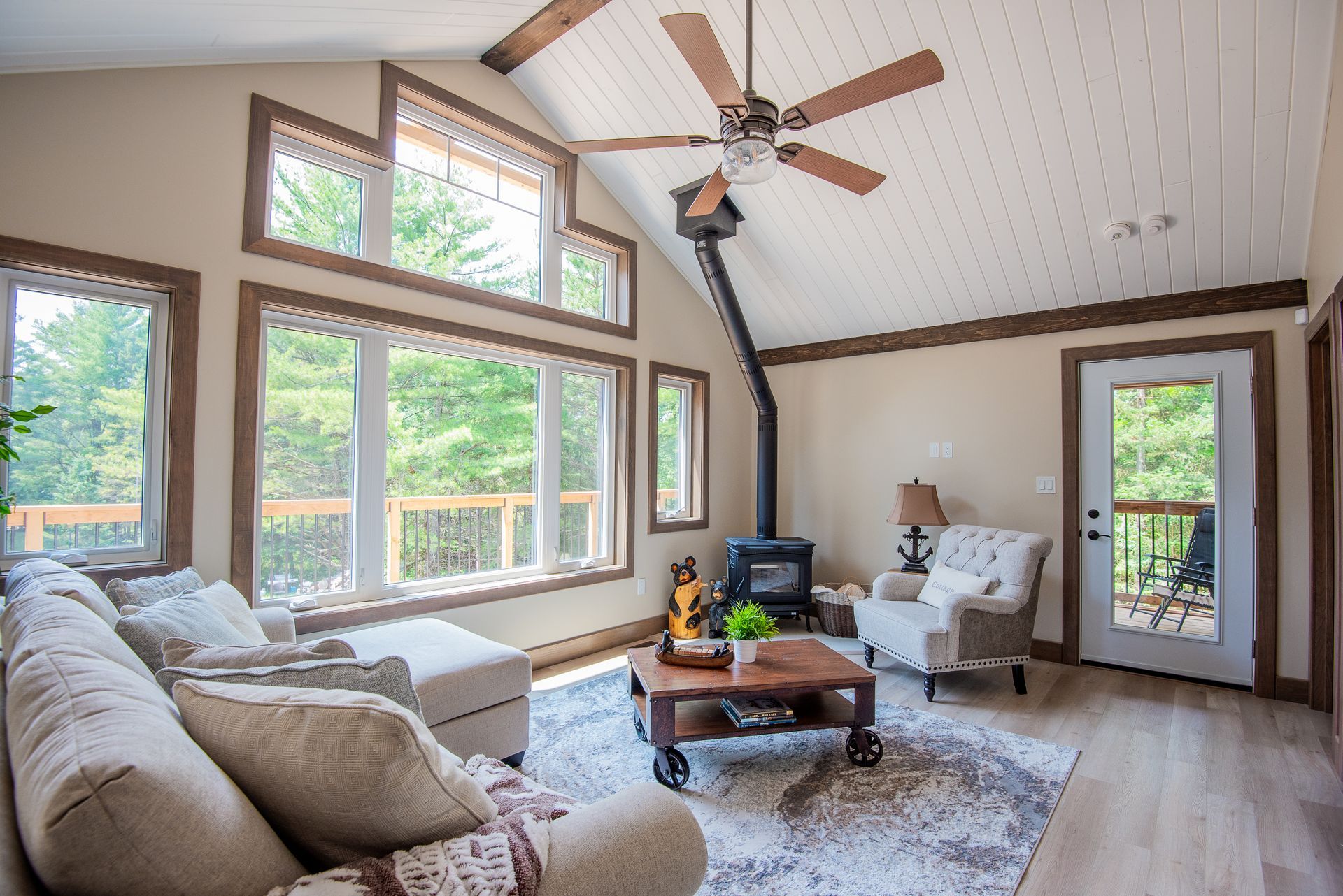 A living room with a couch , chair , coffee table and ceiling fan.