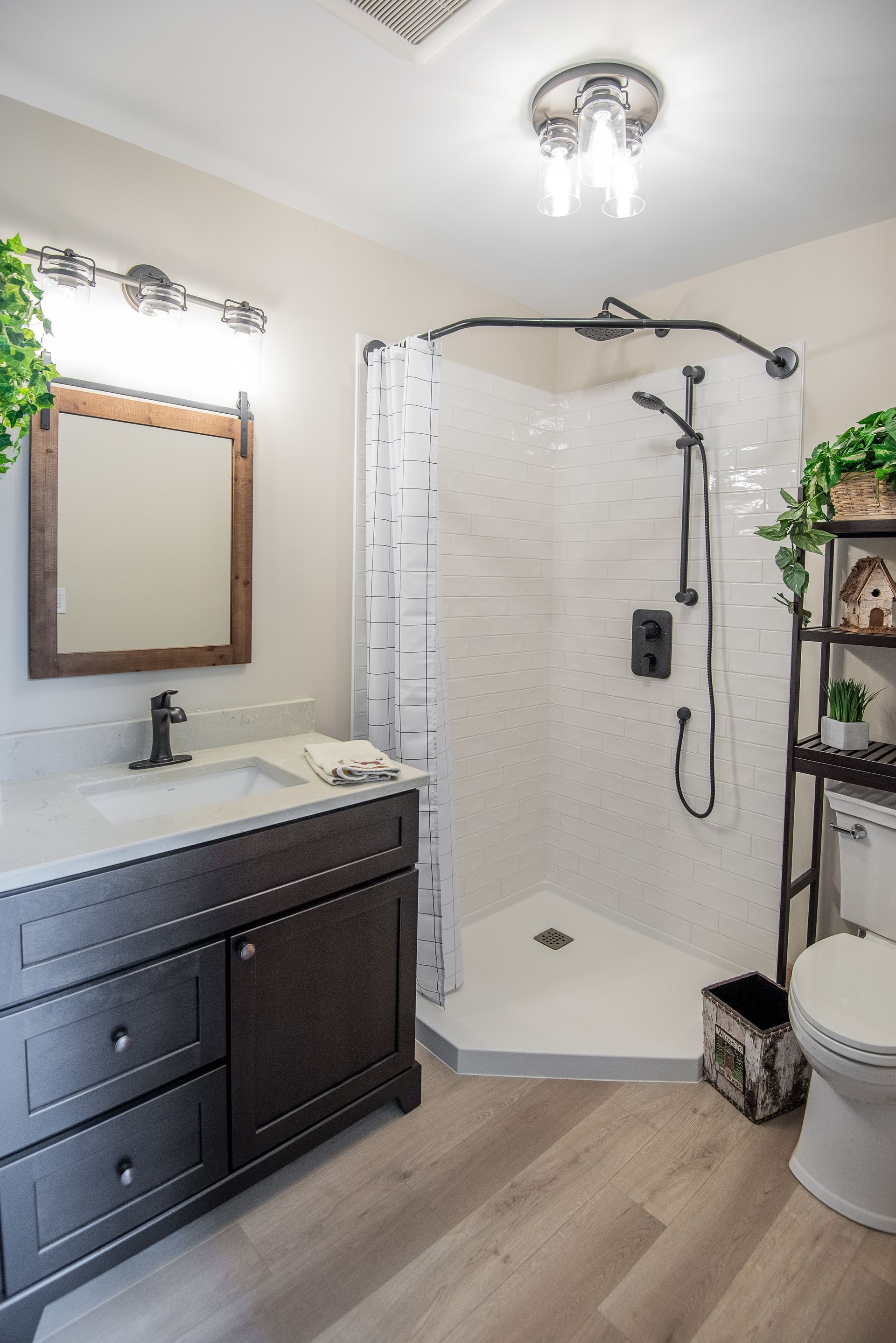 A bathroom with a sink , toilet , shower and mirror.