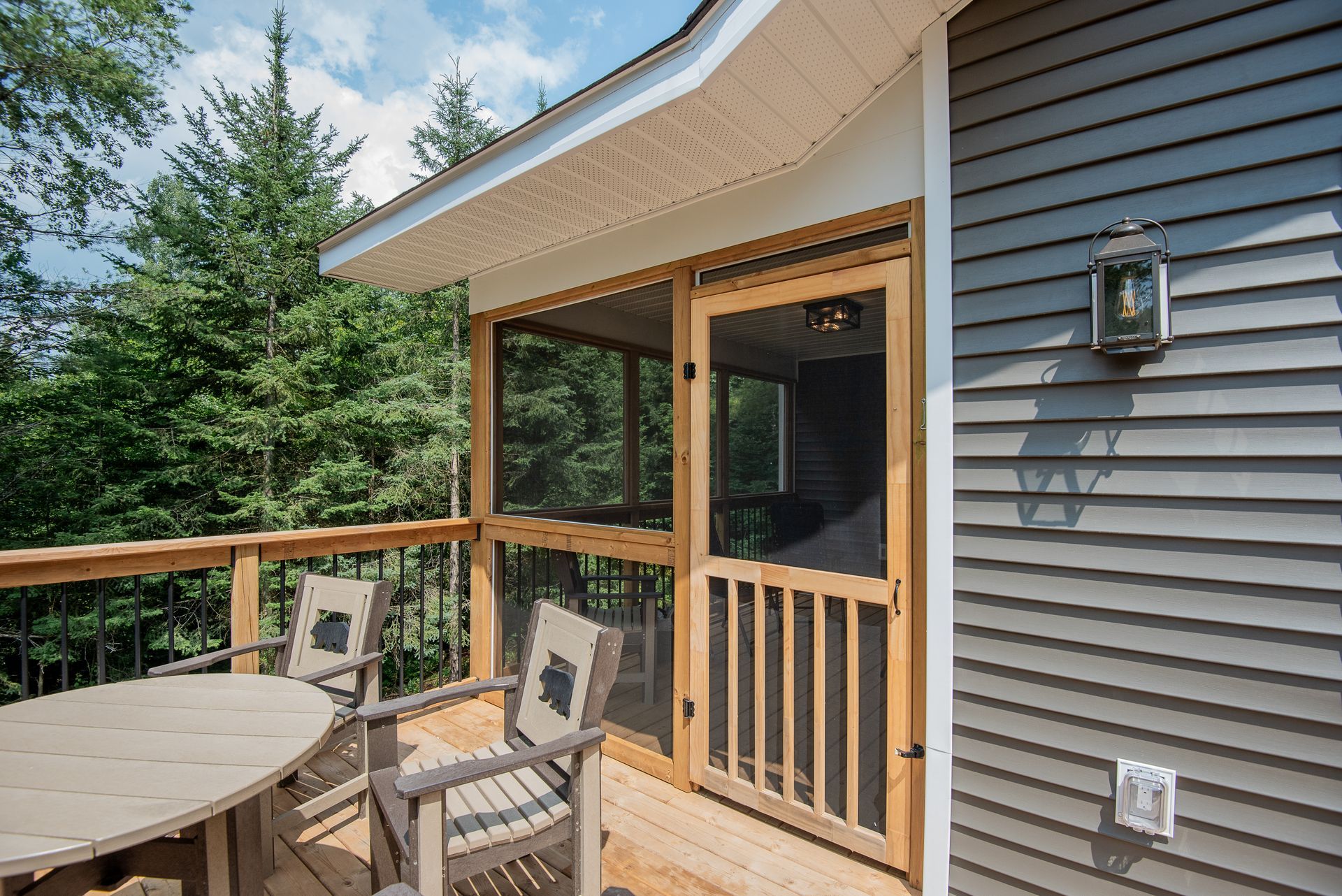 A screened in porch with a table and chairs