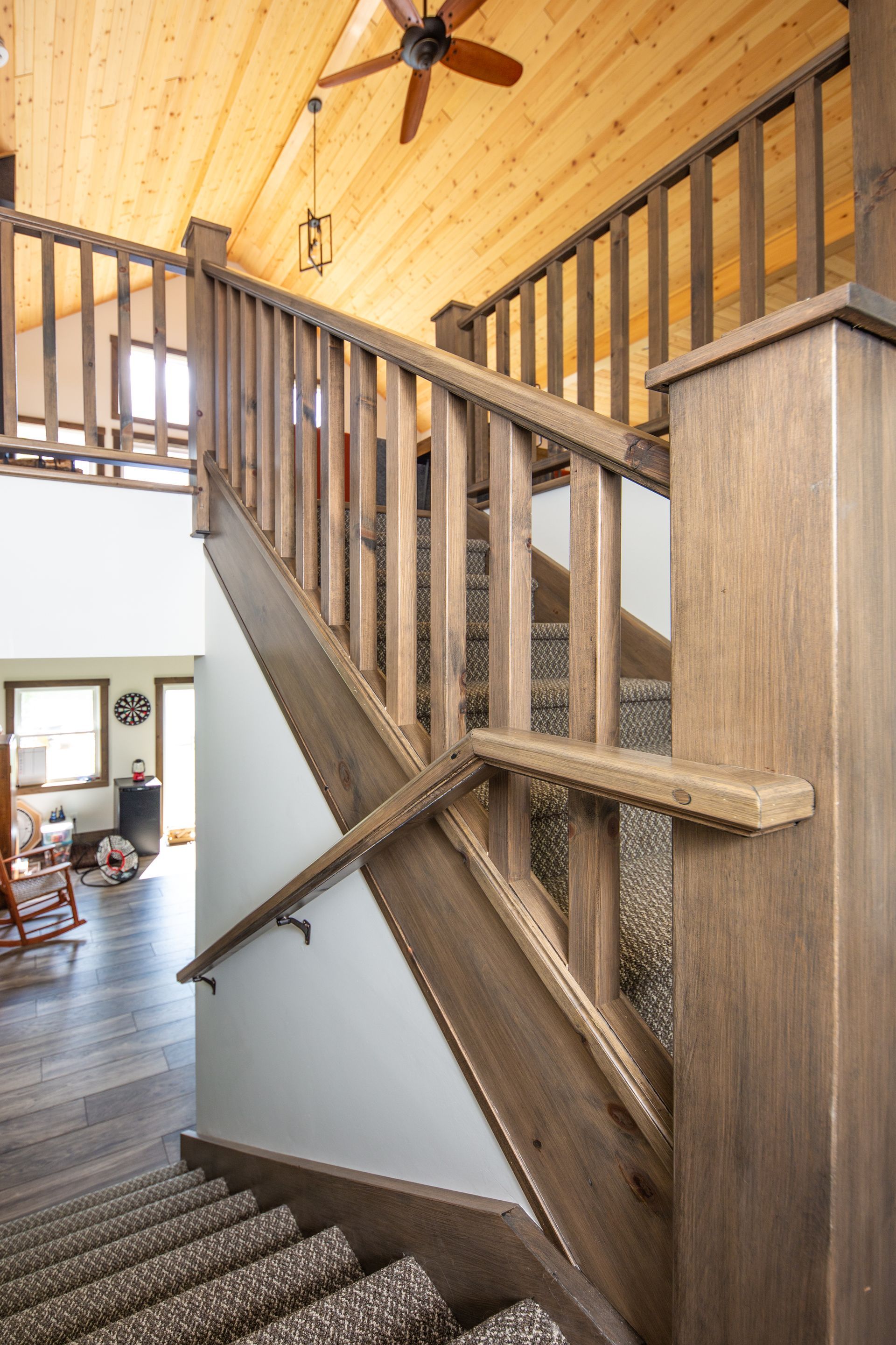 A wooden staircase in a house with a ceiling fan