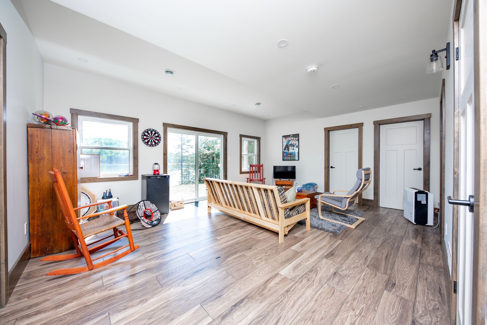 A living room with a couch , rocking chairs , and a television.