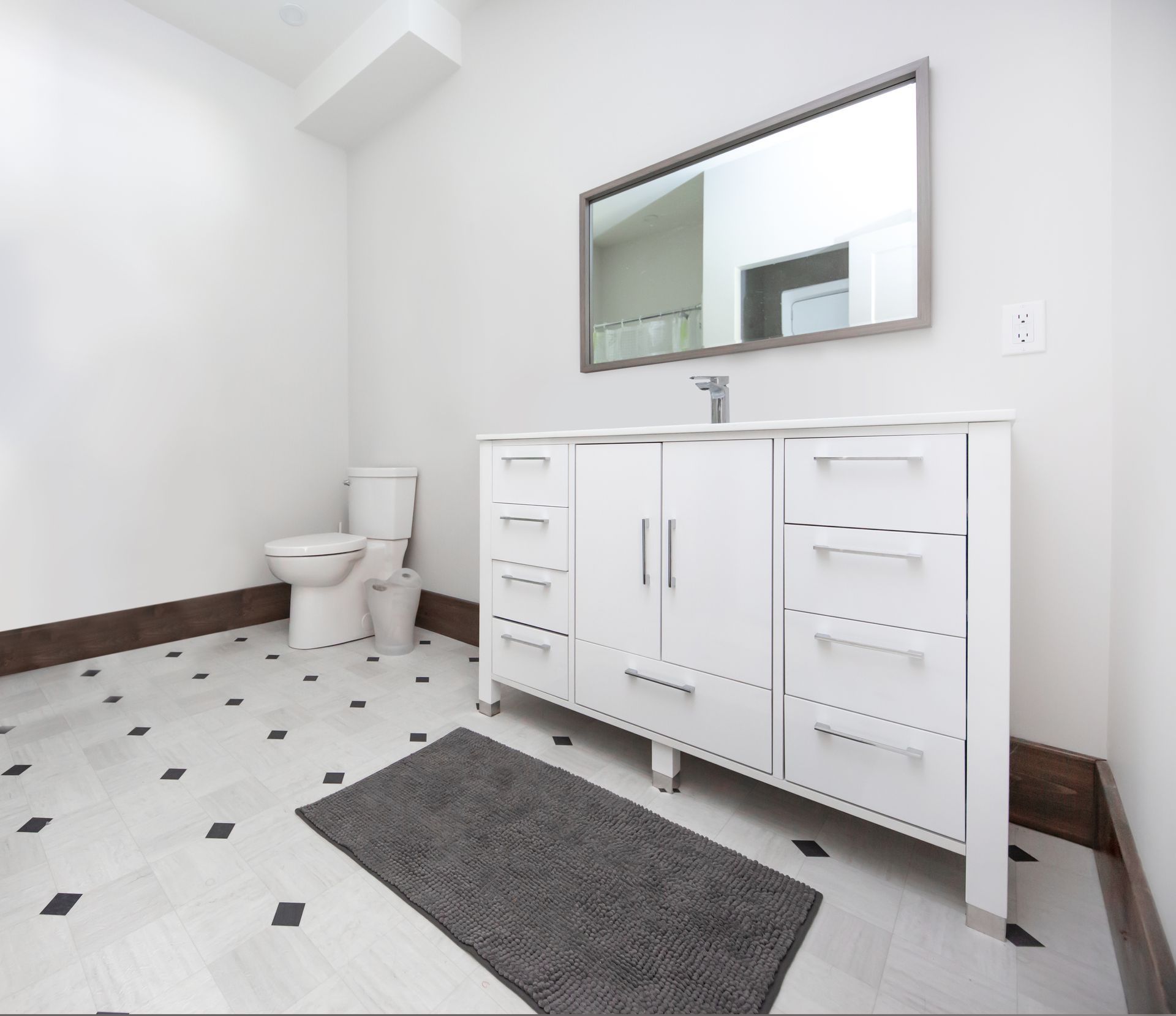 A bathroom with a toilet a sink and a mirror