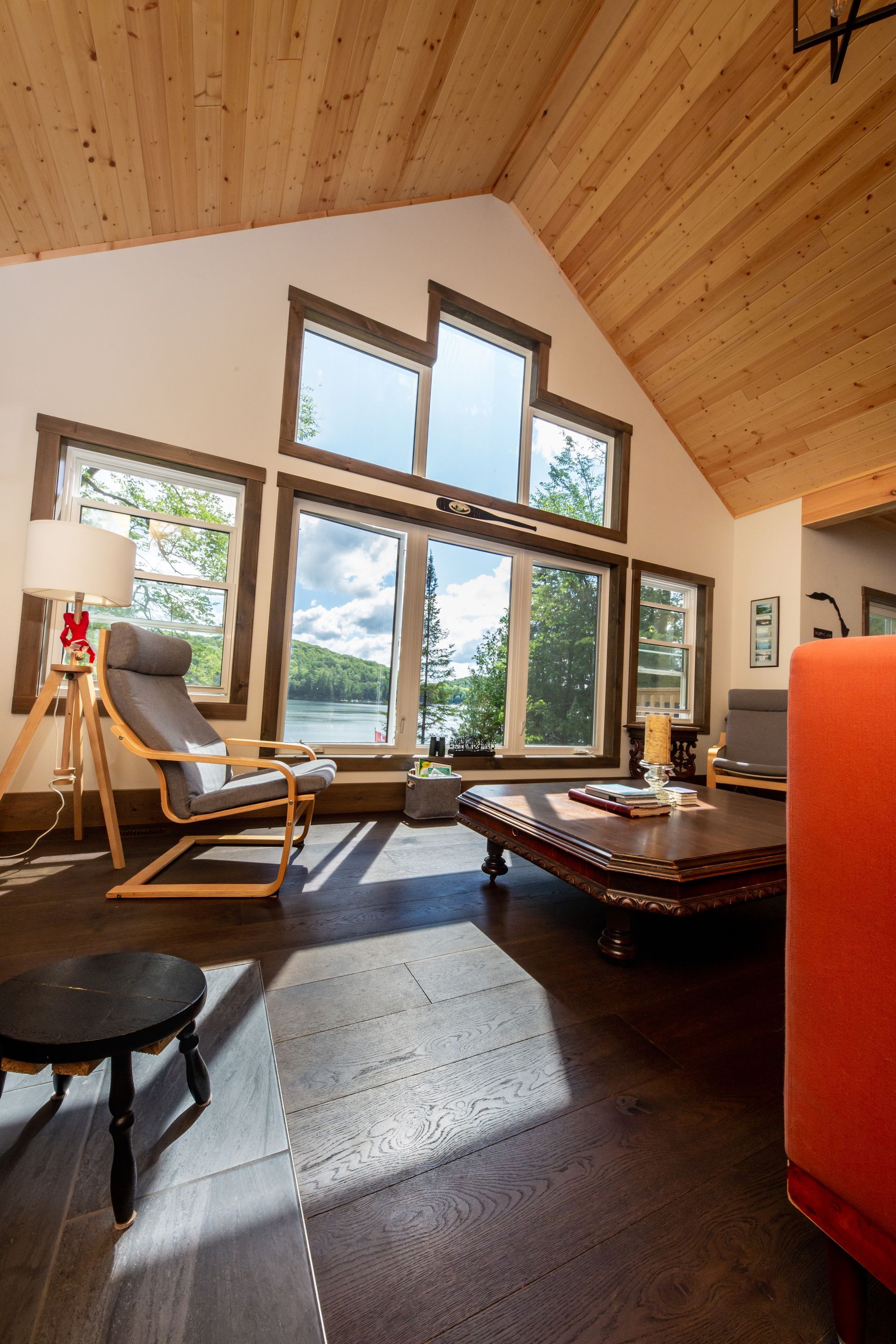 A living room with a vaulted ceiling and lots of windows.